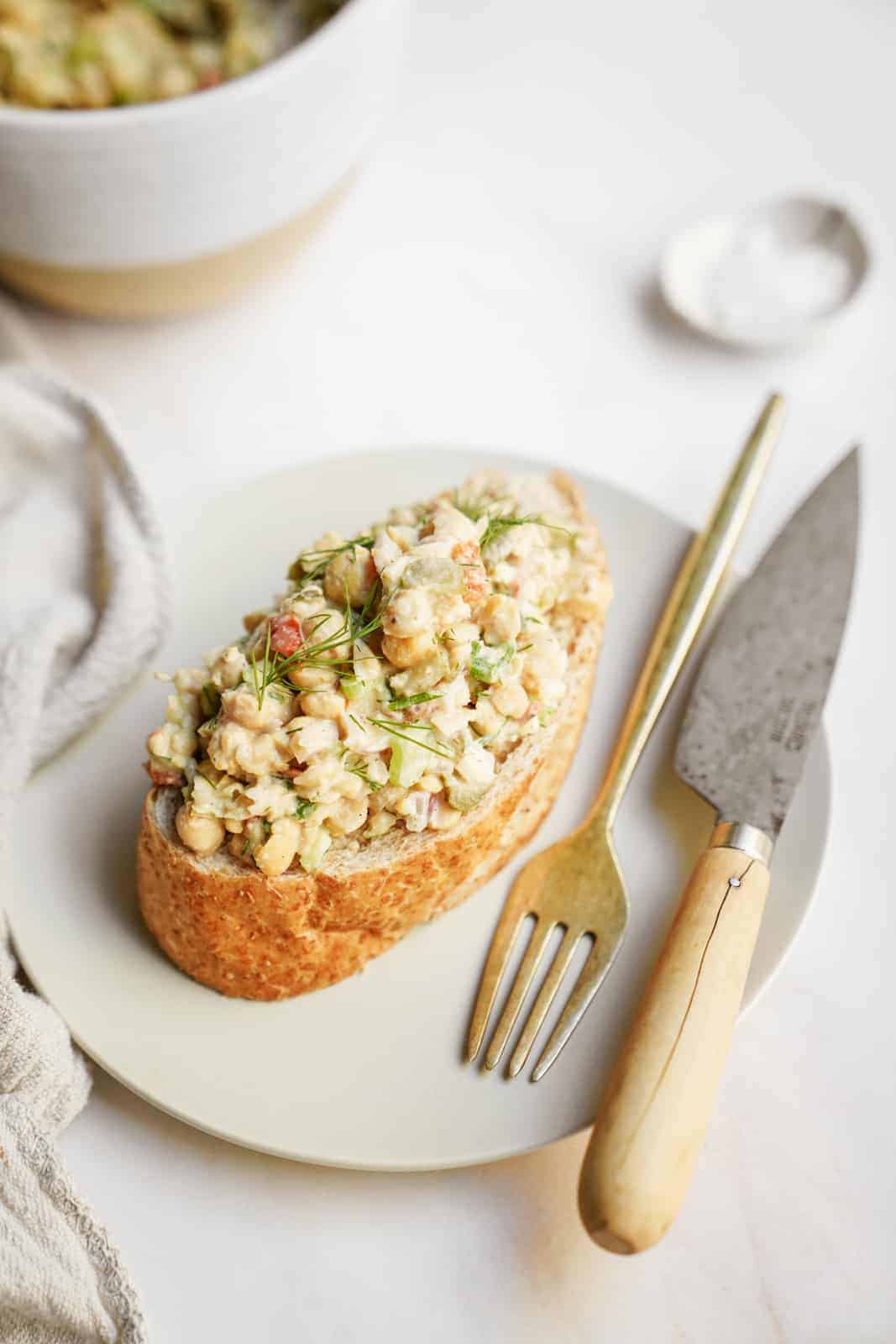 Mashed Chickpea Salad sitting on a piece of bread on a plate
