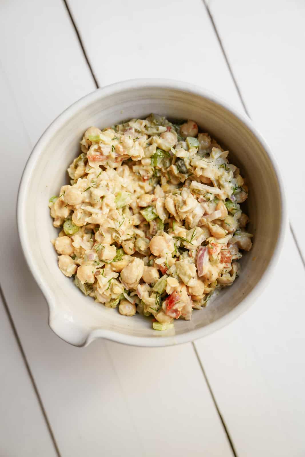 Bowl of Mashed Chickpea Salad on wood countertop.