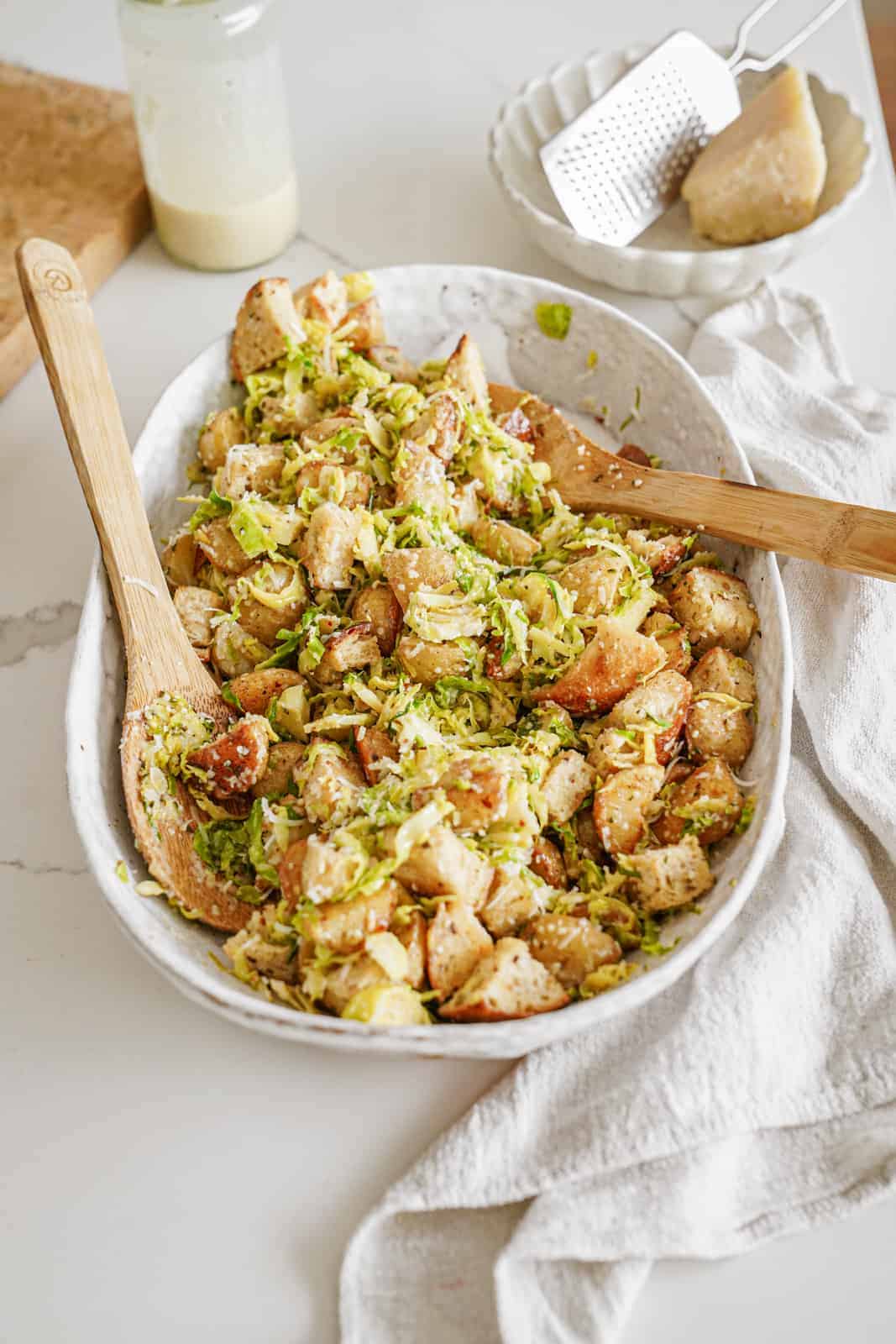 brussel sprout caesar salad in serving dish on countertop.