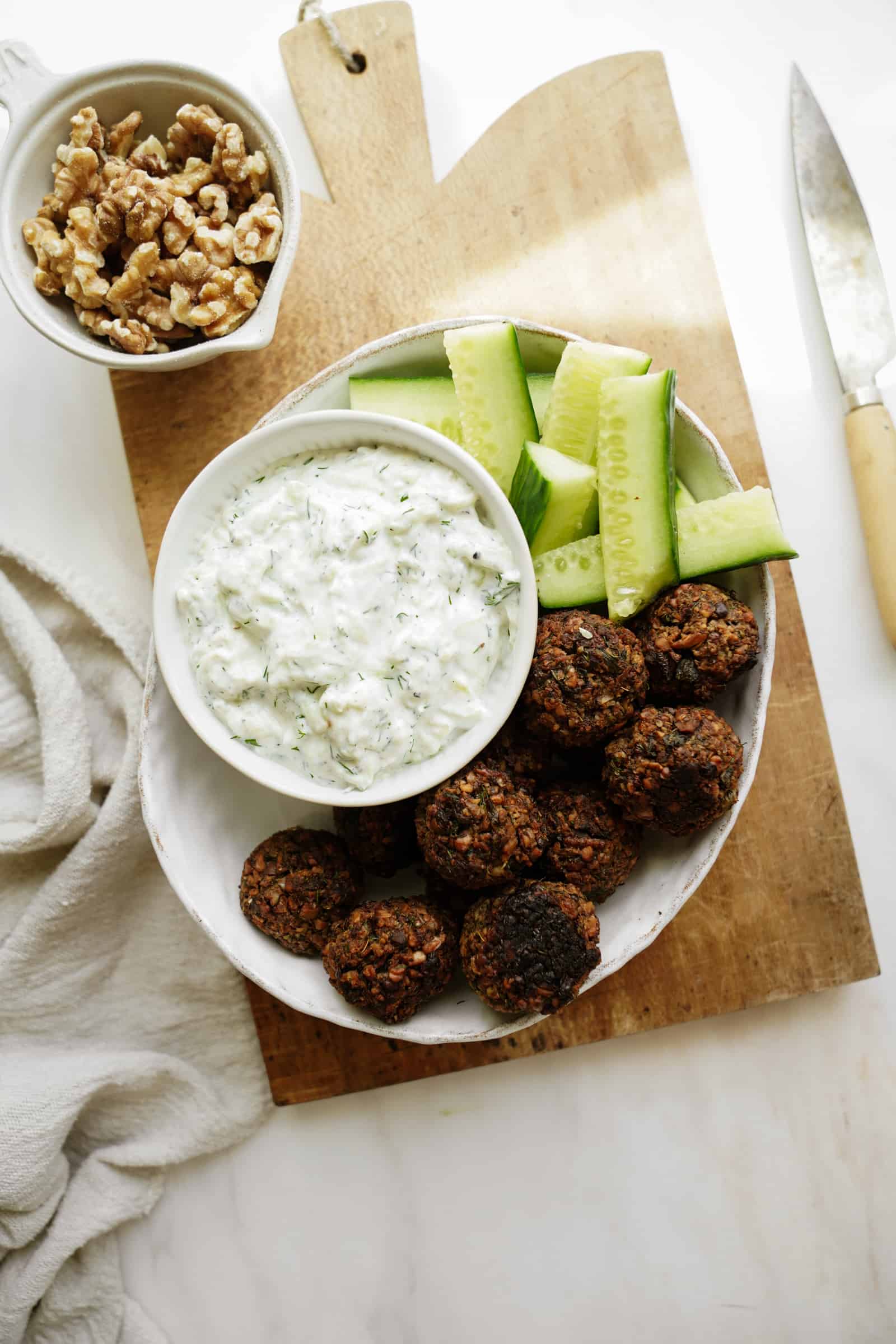 Greek Tzatziki recipe on a plate with fresh cucumber and falafel