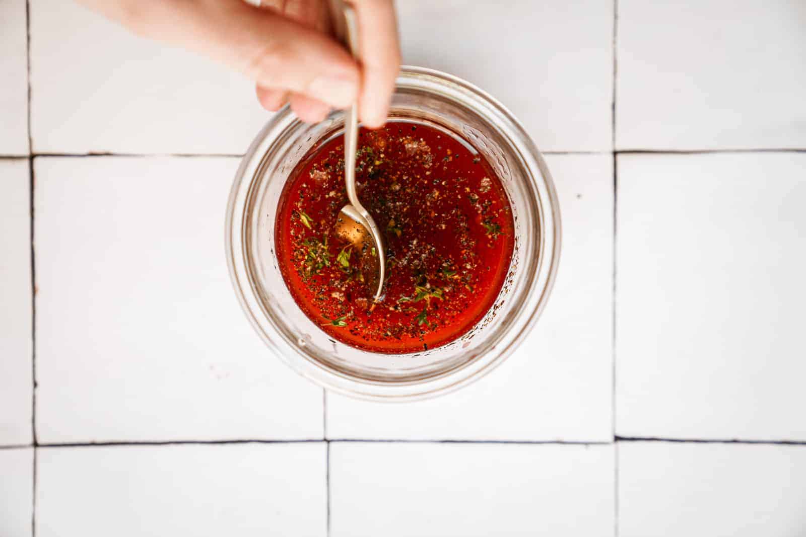 Salad dressing for blood orange salad being mixed with a spoon