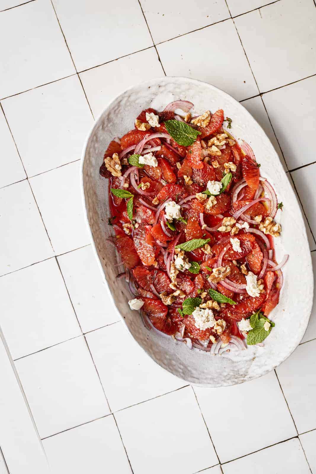 Blood orange salad on white countertop in a serving dish