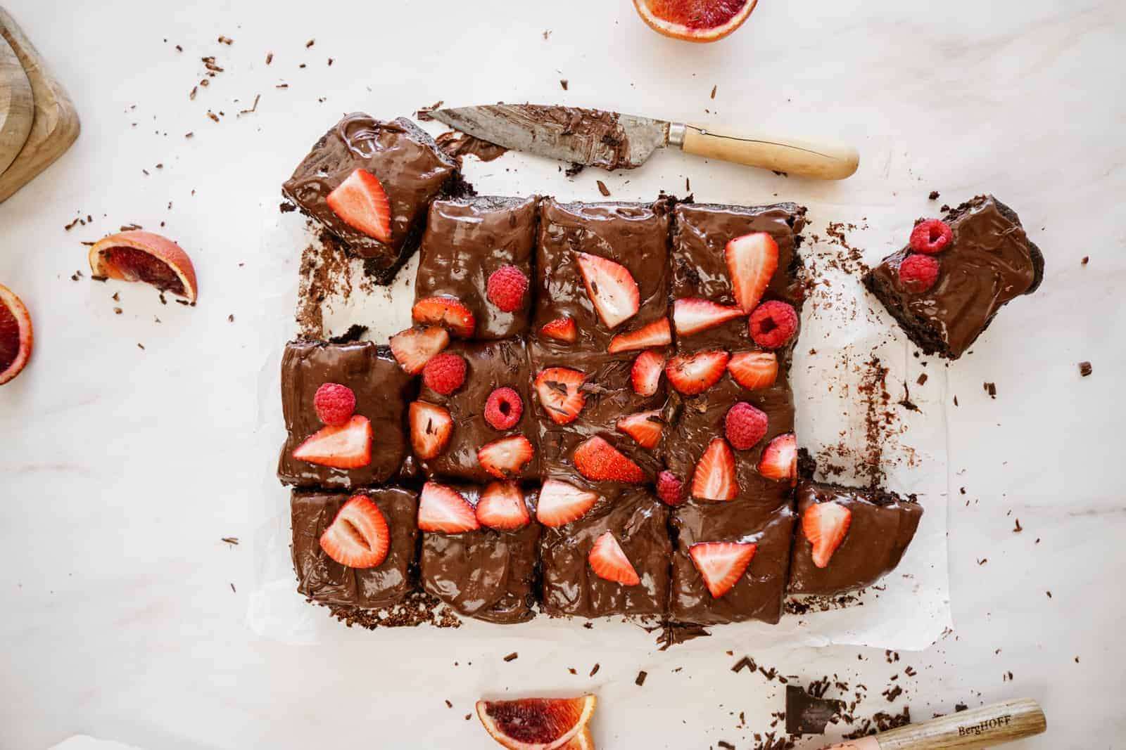 Chocolate Vegan Sheet Cake recipe on countertop cut into squares.