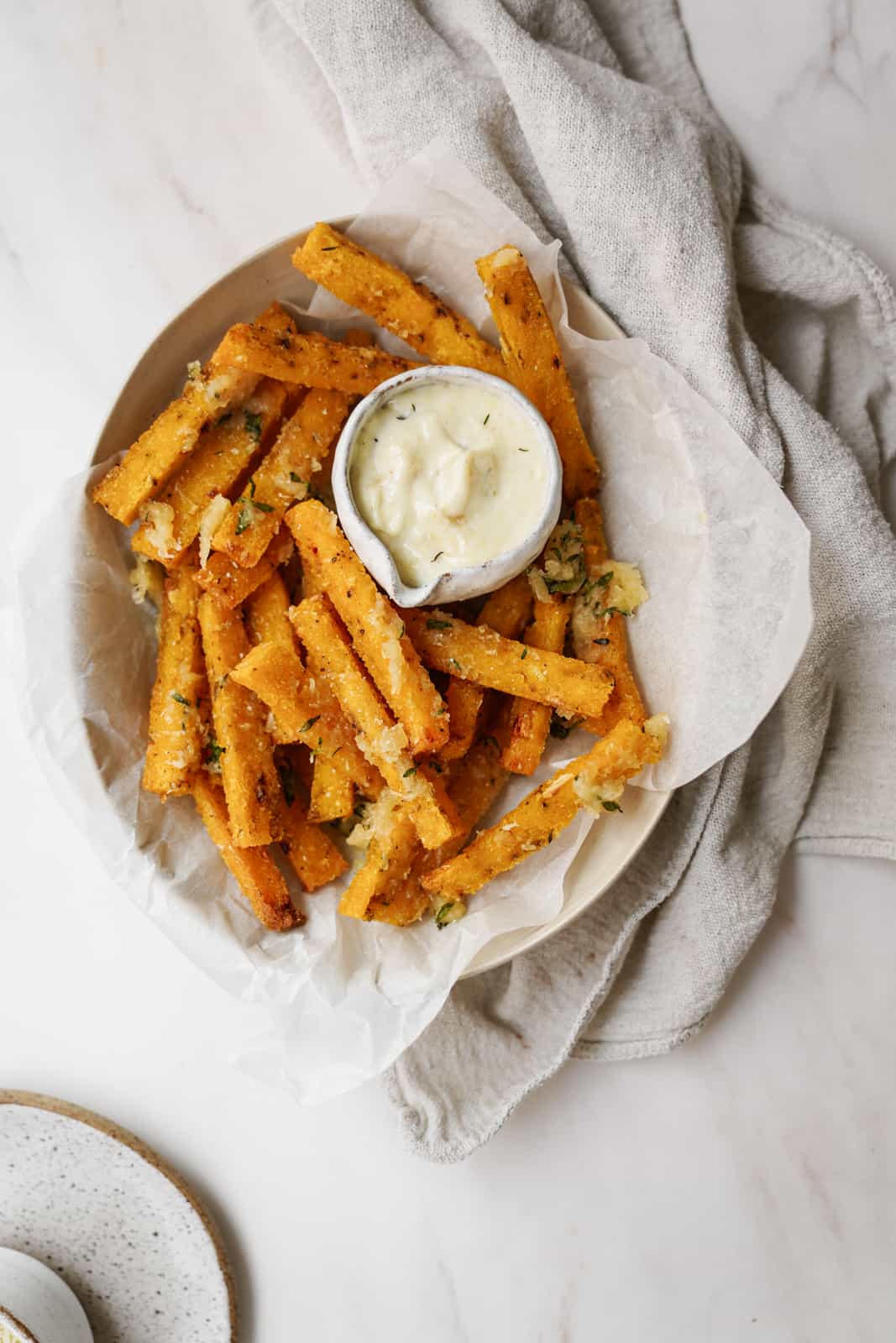 Bowl of vegan polenta fries with aioli dipping sauce