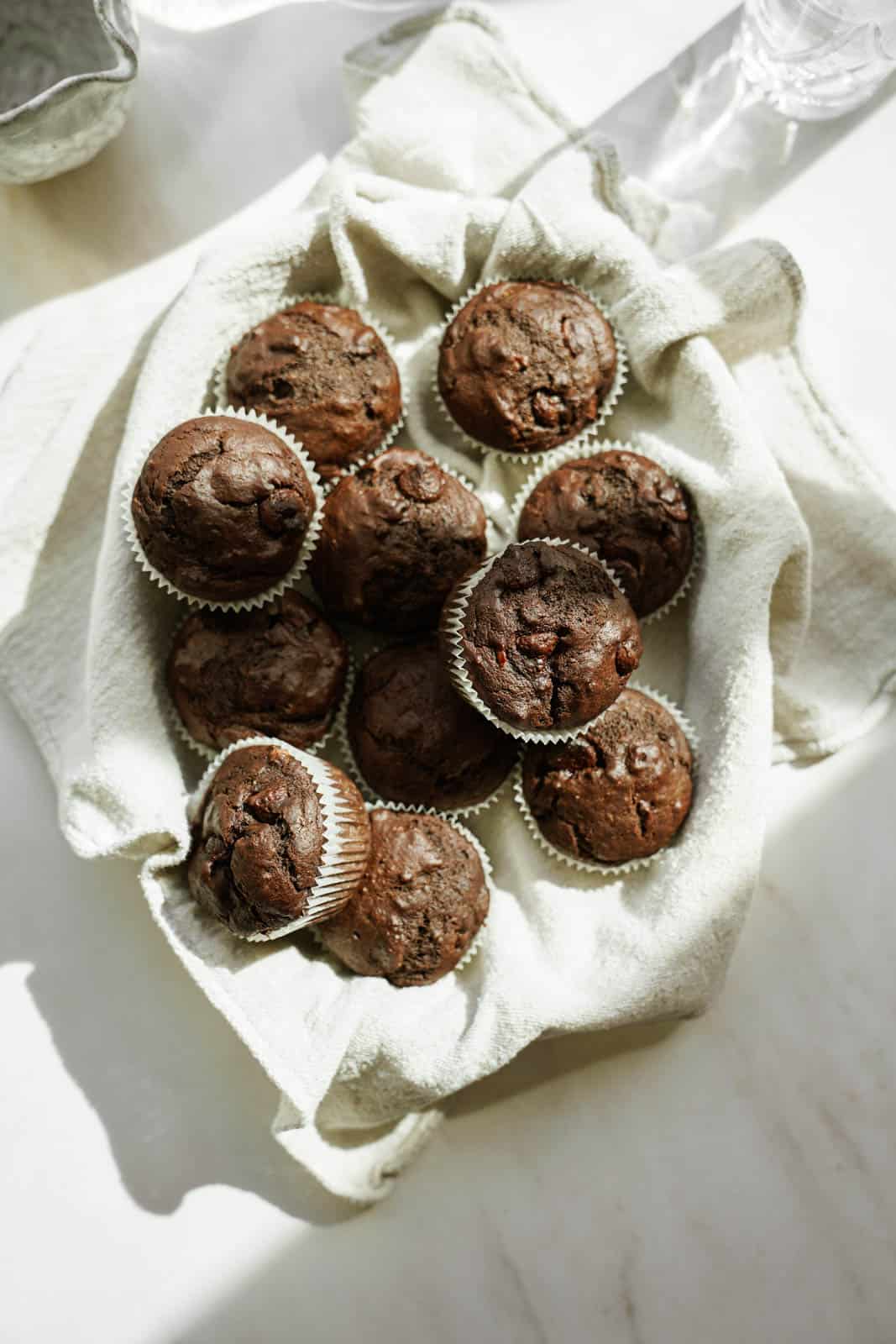 Chocolate muffins in a basket with a white napkin