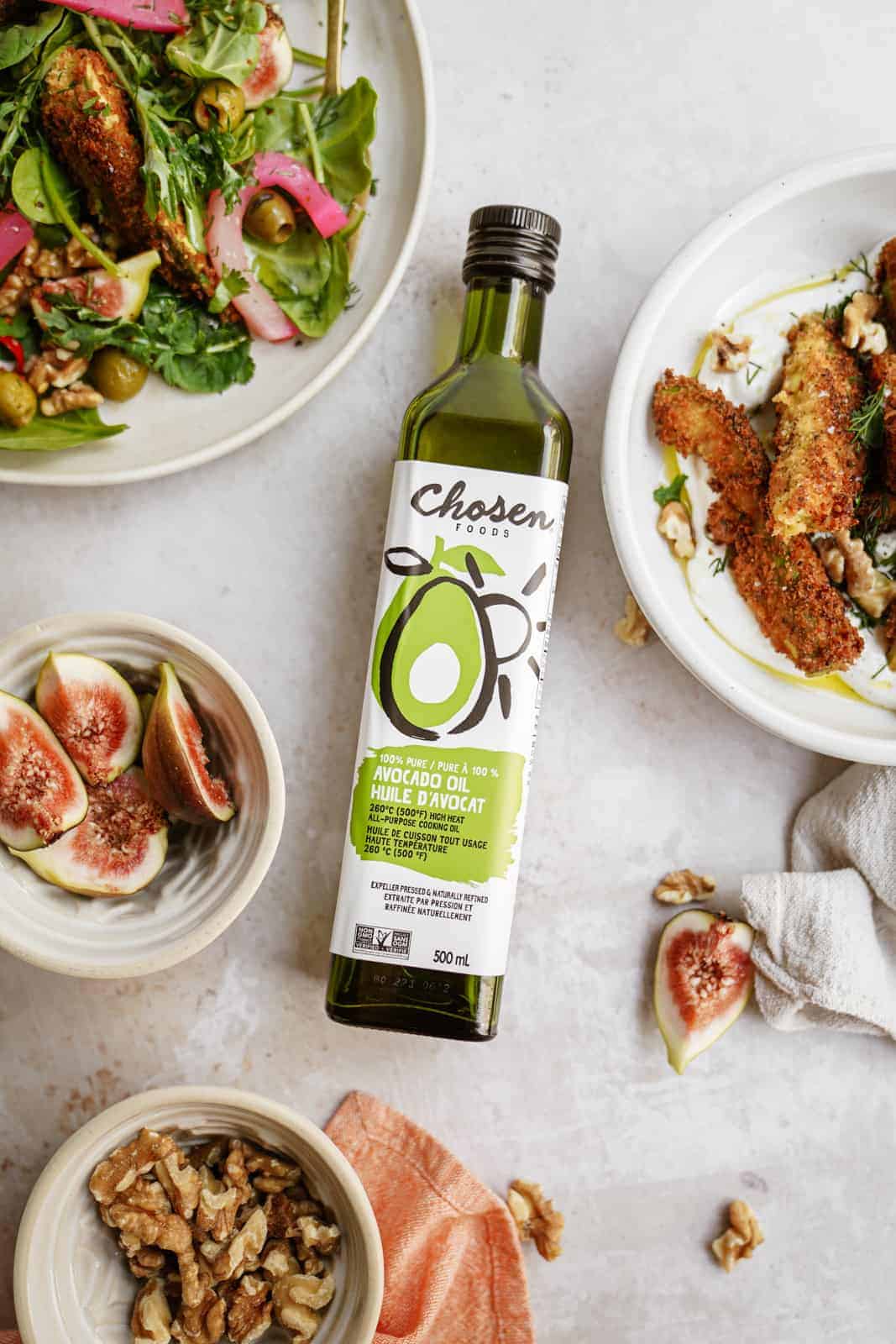 Chosen Foods Avocado Oil on counter surrounded by Avocado Fried Salad on plates