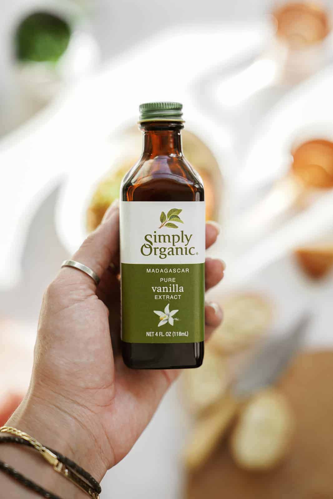 Hand holding a bottle of Simply Organic Vanilla Extract