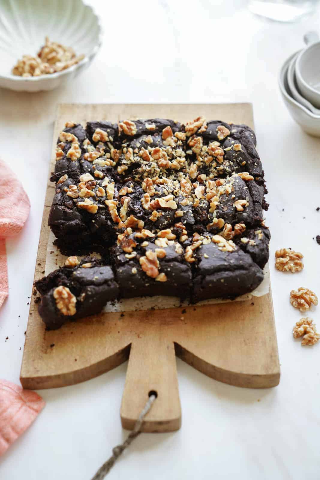 vegan fudge brownies on a cutting board with a piece cut out