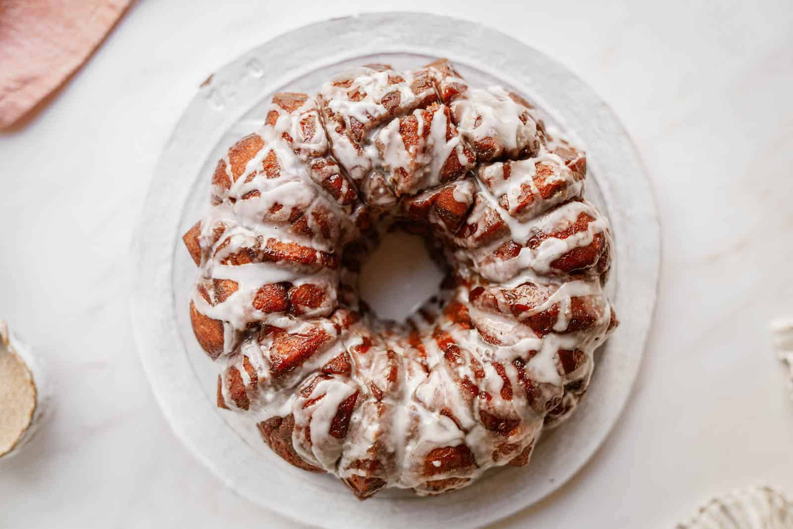 Vegan monkey bread on plate drizzled with icing