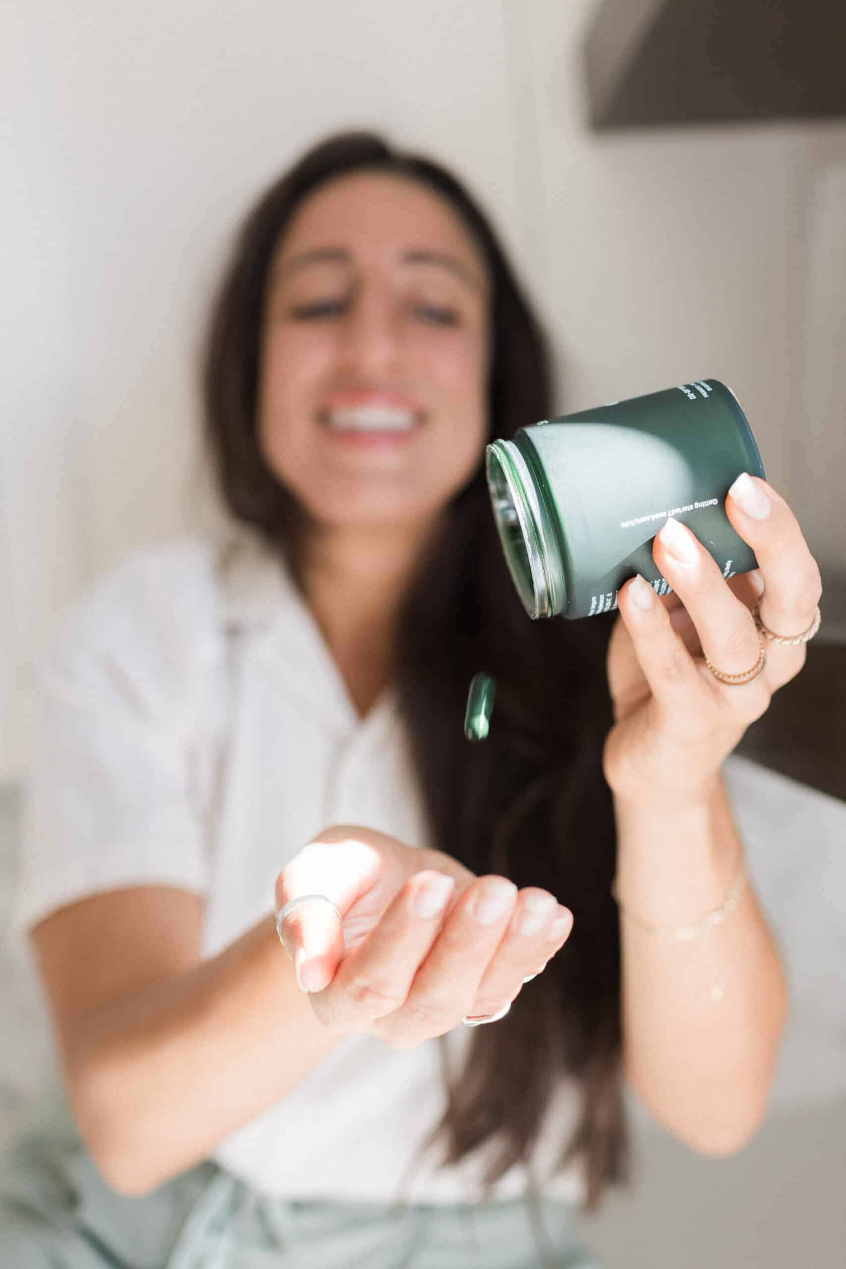 Maria dumping a Seed probiotic into her hand