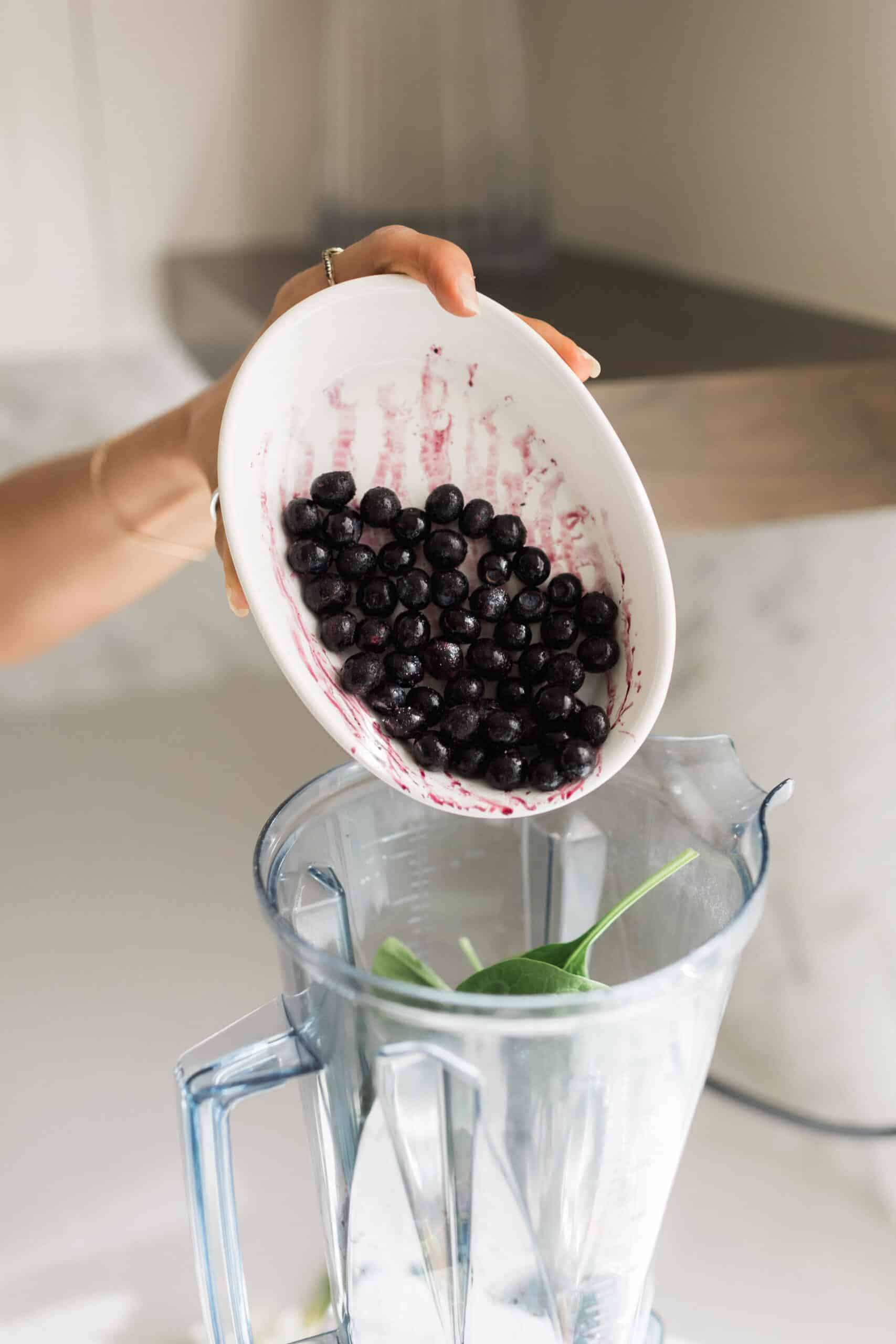 Blueberries being added to blender for banana berry smoothie