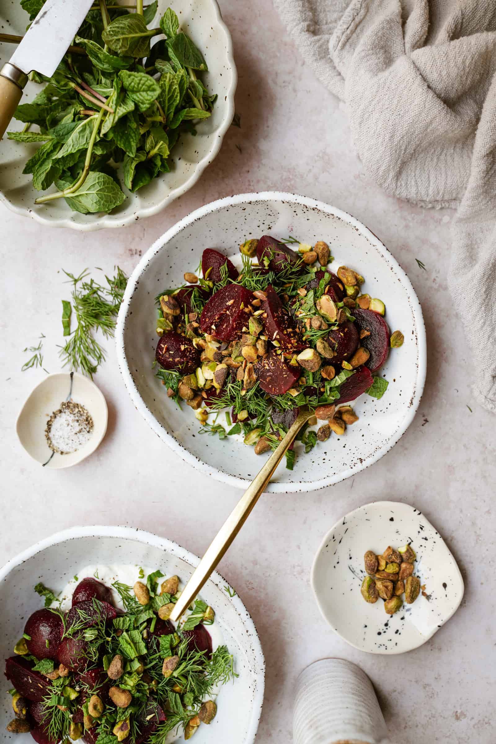Roasted beet salad with feta surrounded by ingredients on table
