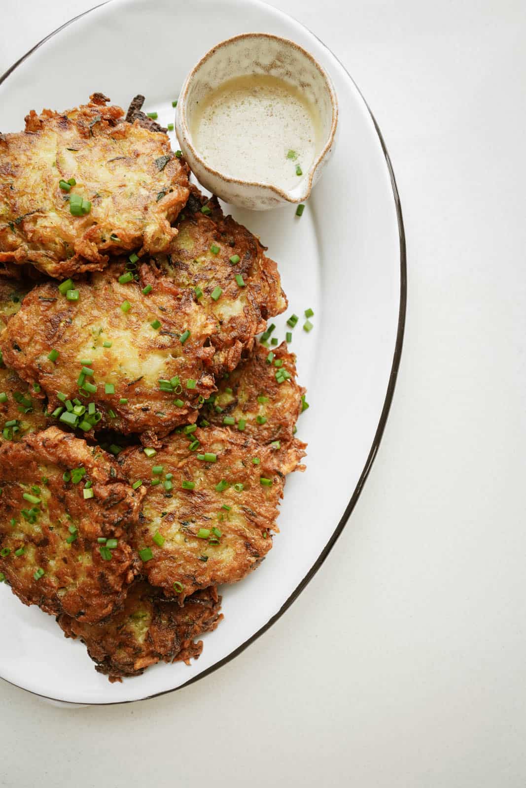 Zucchini Potato Pancakes on serving plate with dipping sauce