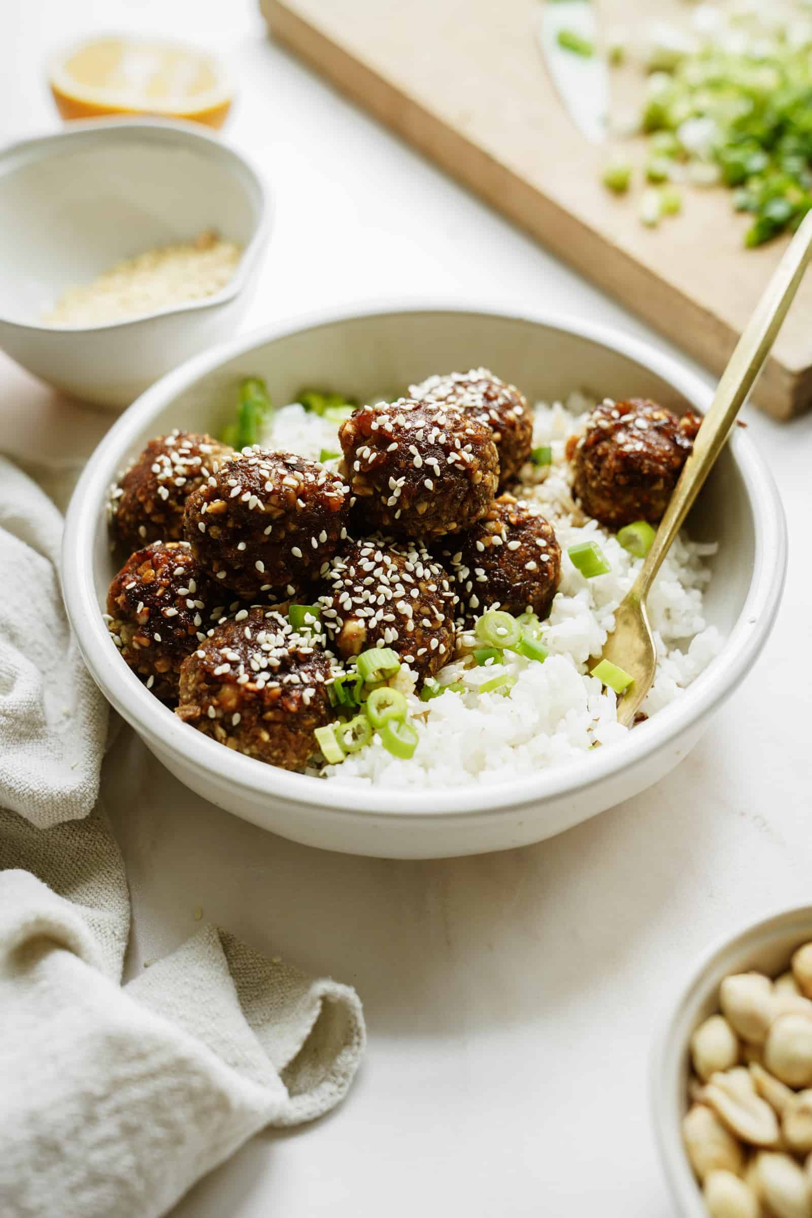 meatballs on a bed of rice in a bowl with a spoon