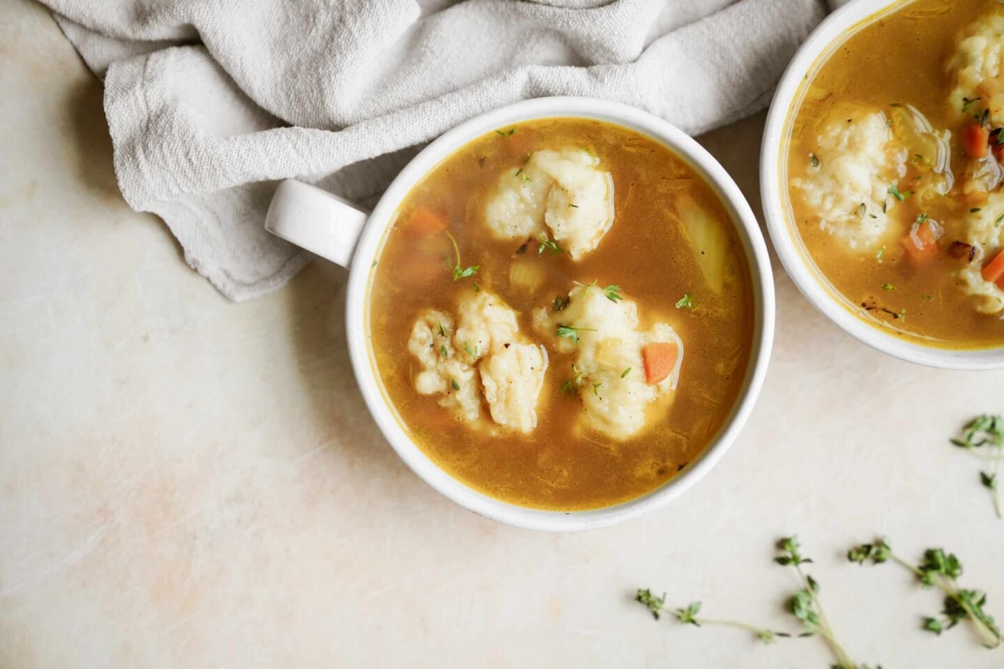 vegan dumplings in vegetable soup in white mugs on tabletop