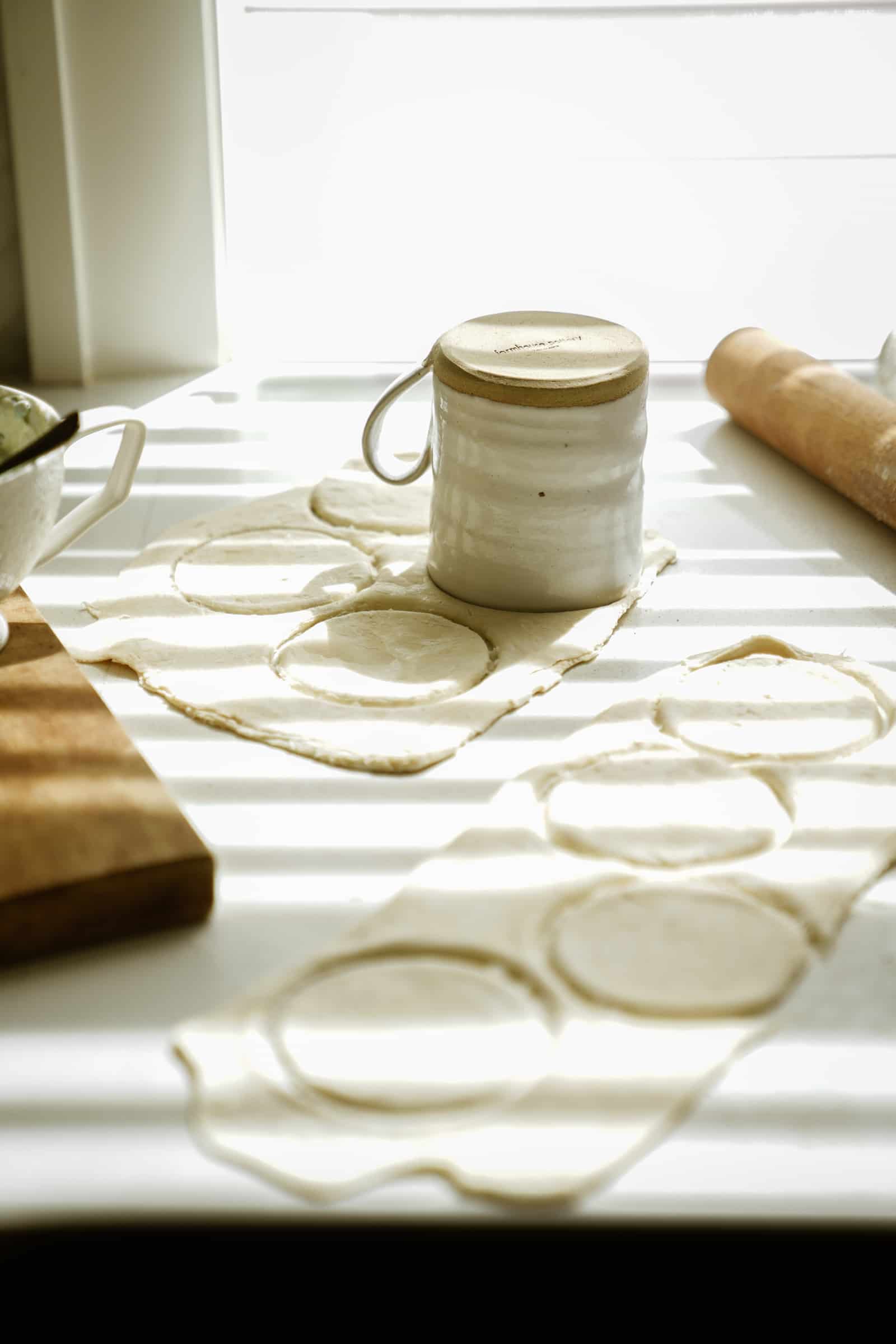 Dough for hot pockets being cut with a mug