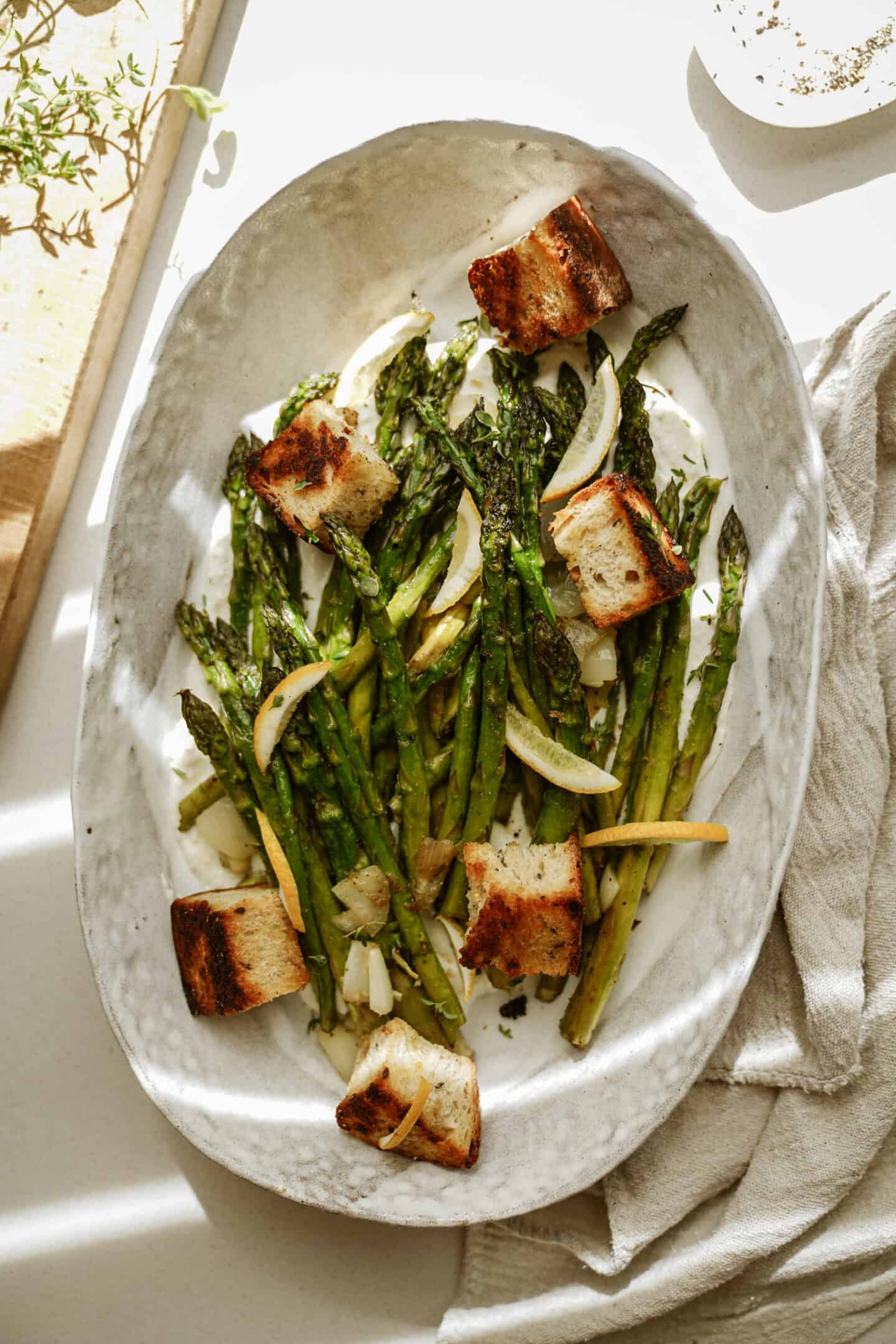 Greek marinated asparagus with croutons in a serving dish