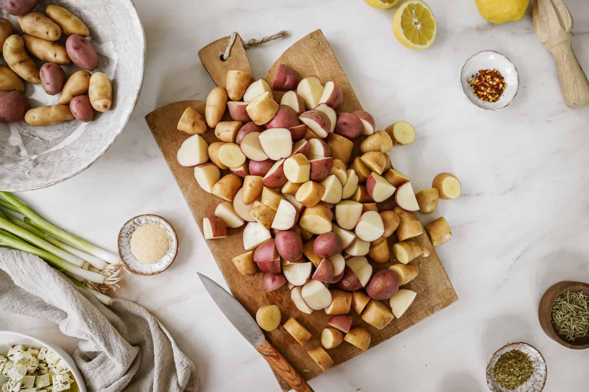 Cut potatoes on cutting board for Greek potato salad