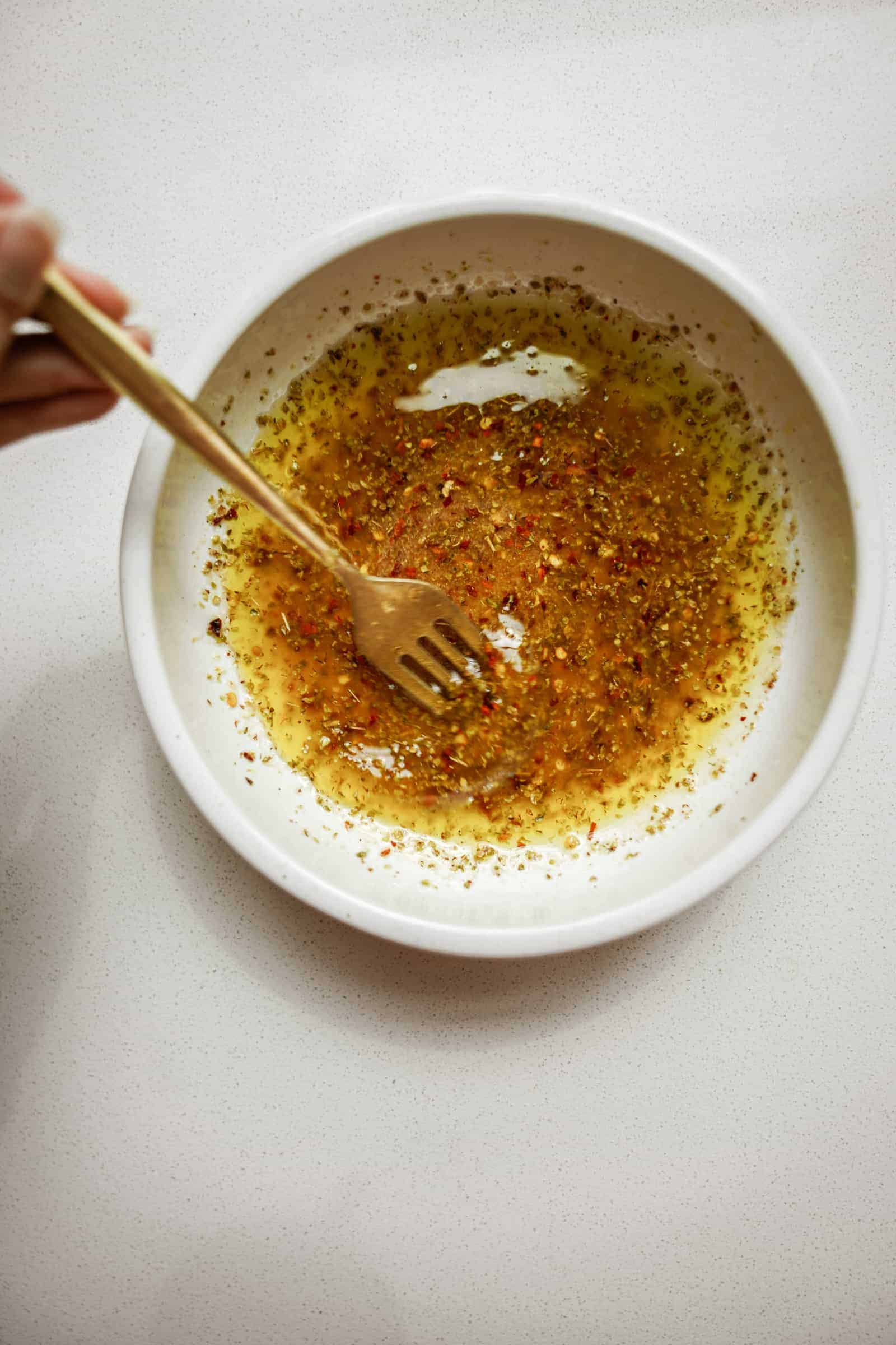 Ingredients in bowl full of spices for Greek Potato Salad