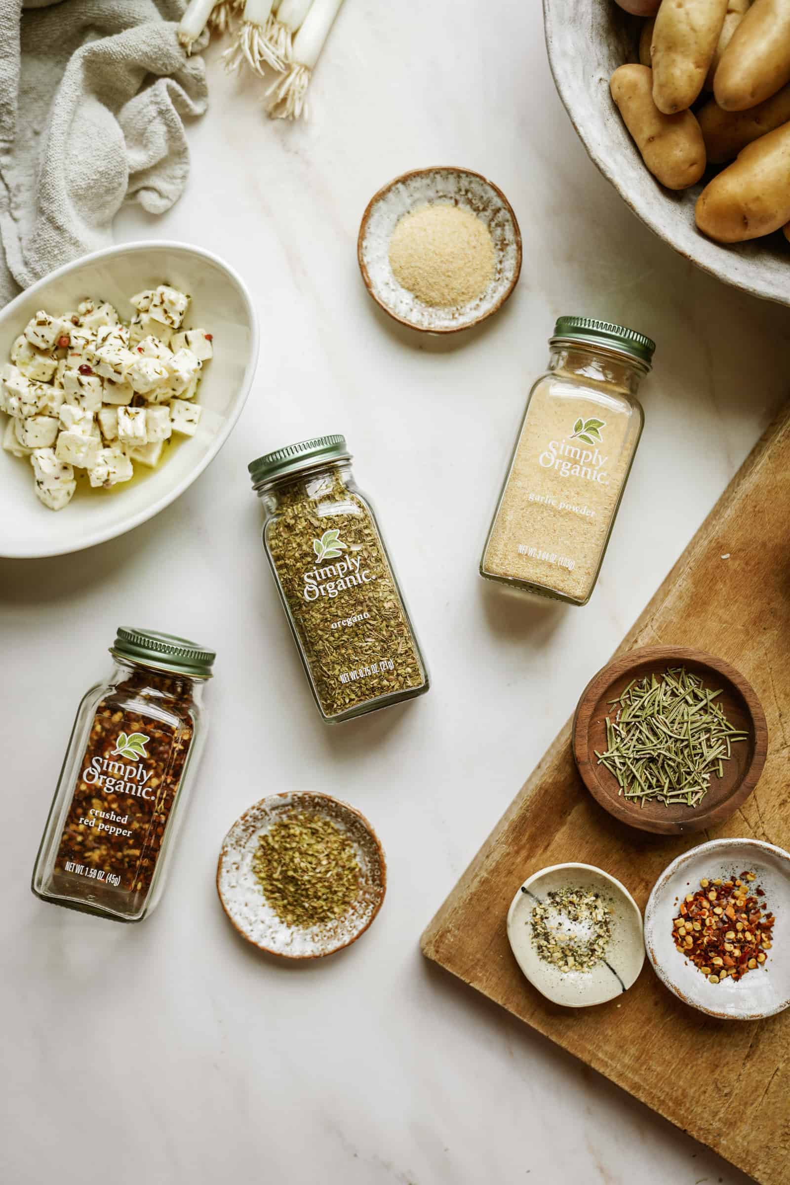 Simply Organic spices on a table surrounded by ingredients