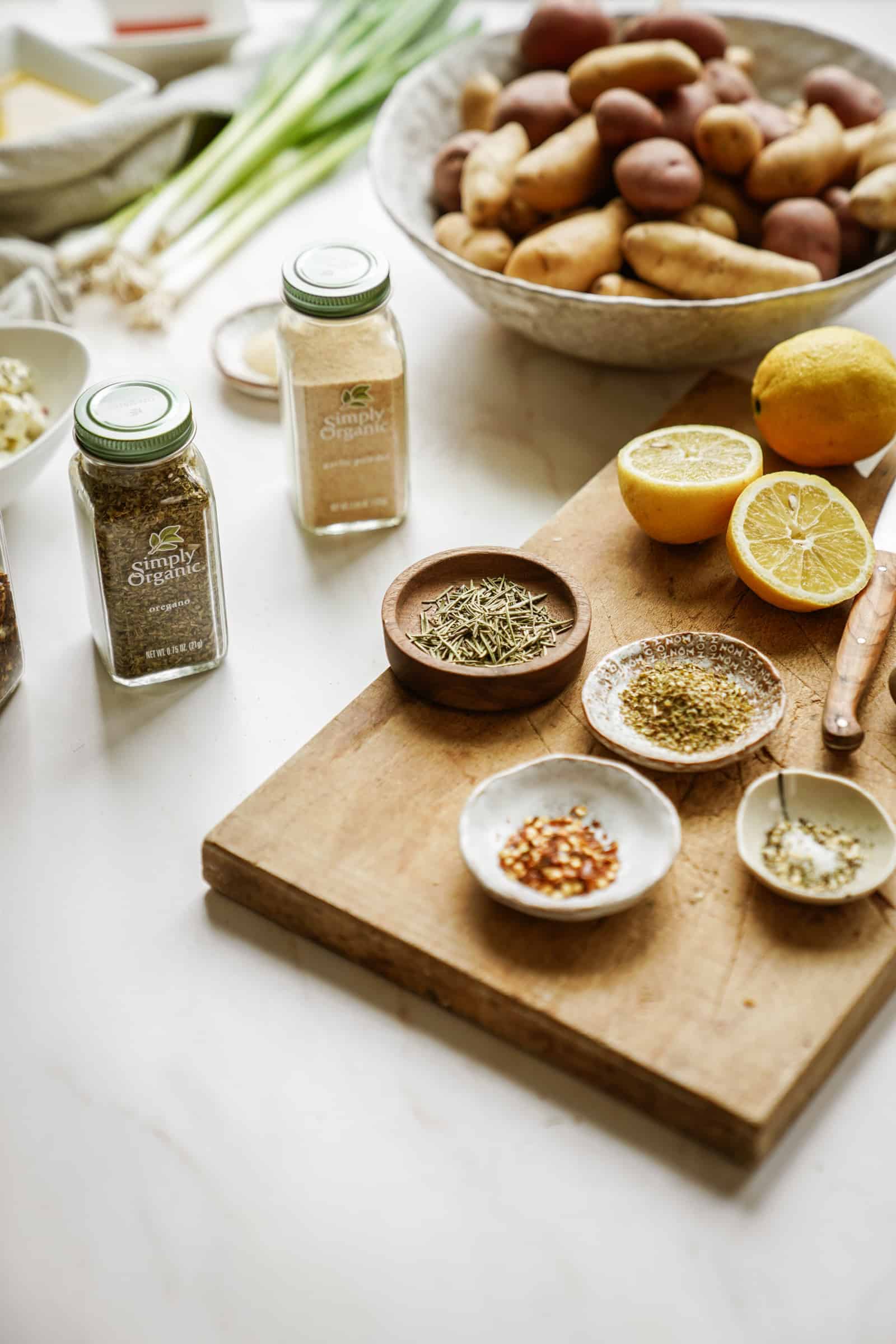 Spices and ingredients on cutting board ready for Greek Potato Salad