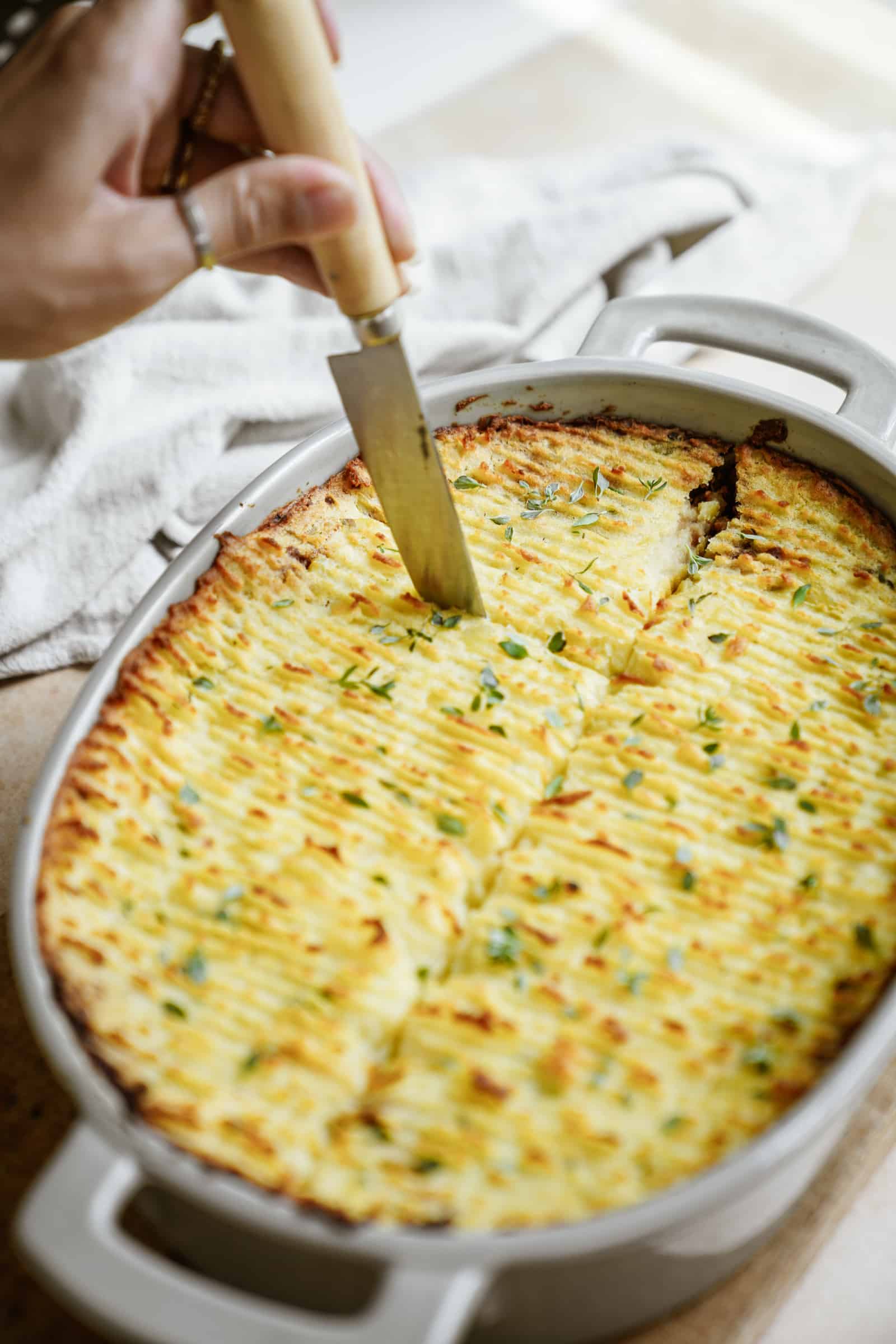 Cutting into a vegan shepherd's pie