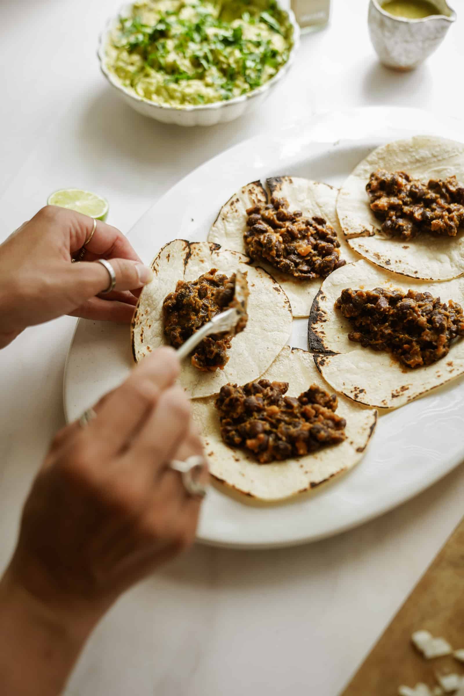 Taco filling for Vegetarian Black Bean Tacos being put in tortilla shells