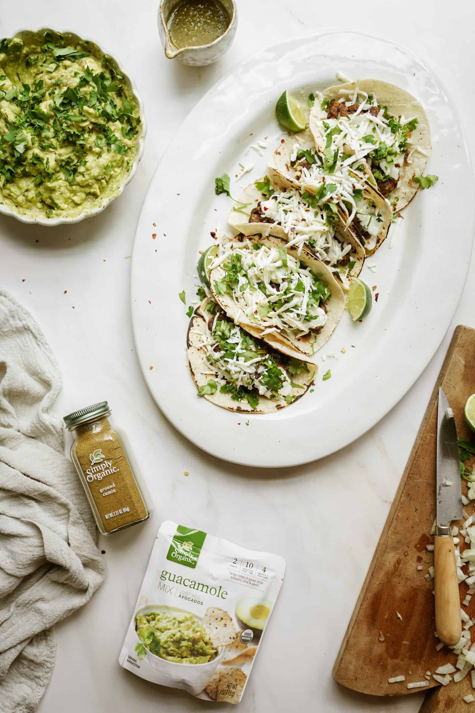 Vegetarian black bean tacos on a serving dish next to guacamole