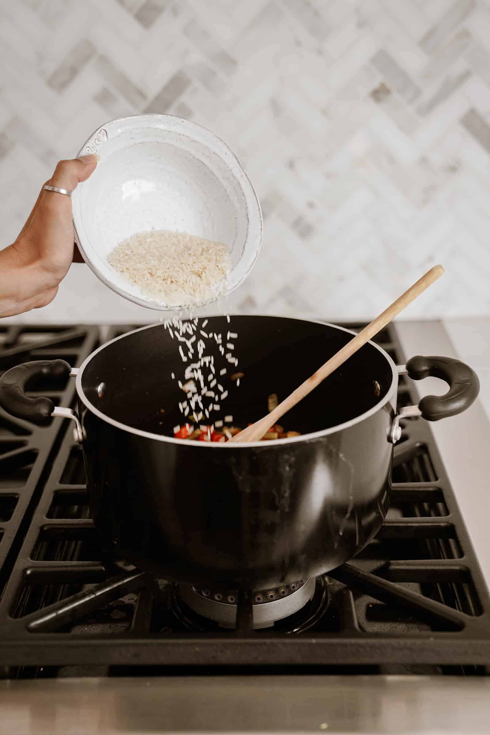 Adding rice to pot of soup