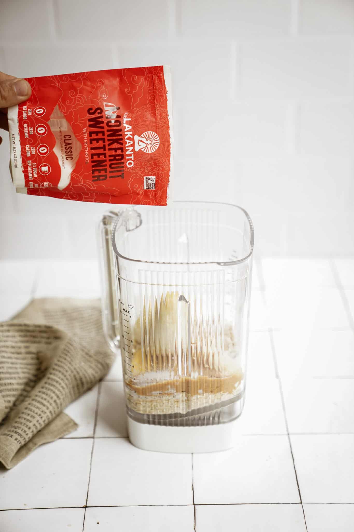 Sweetener being added into a blender for peanut butter banana pancakes