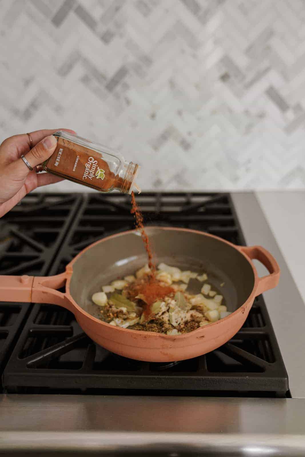 Adding spices into a pan on the stove