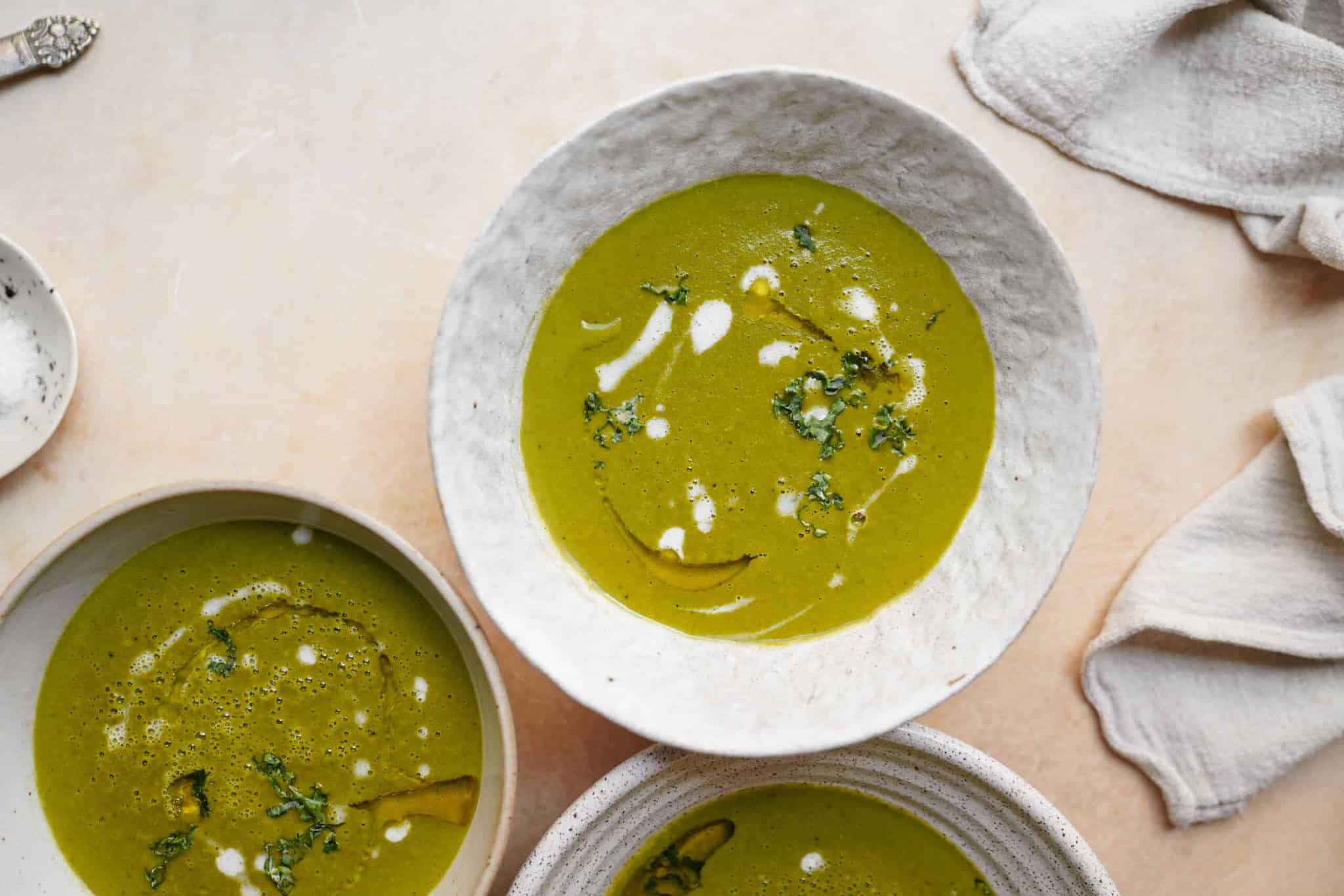 potato kale Soup in white bowls on countertop