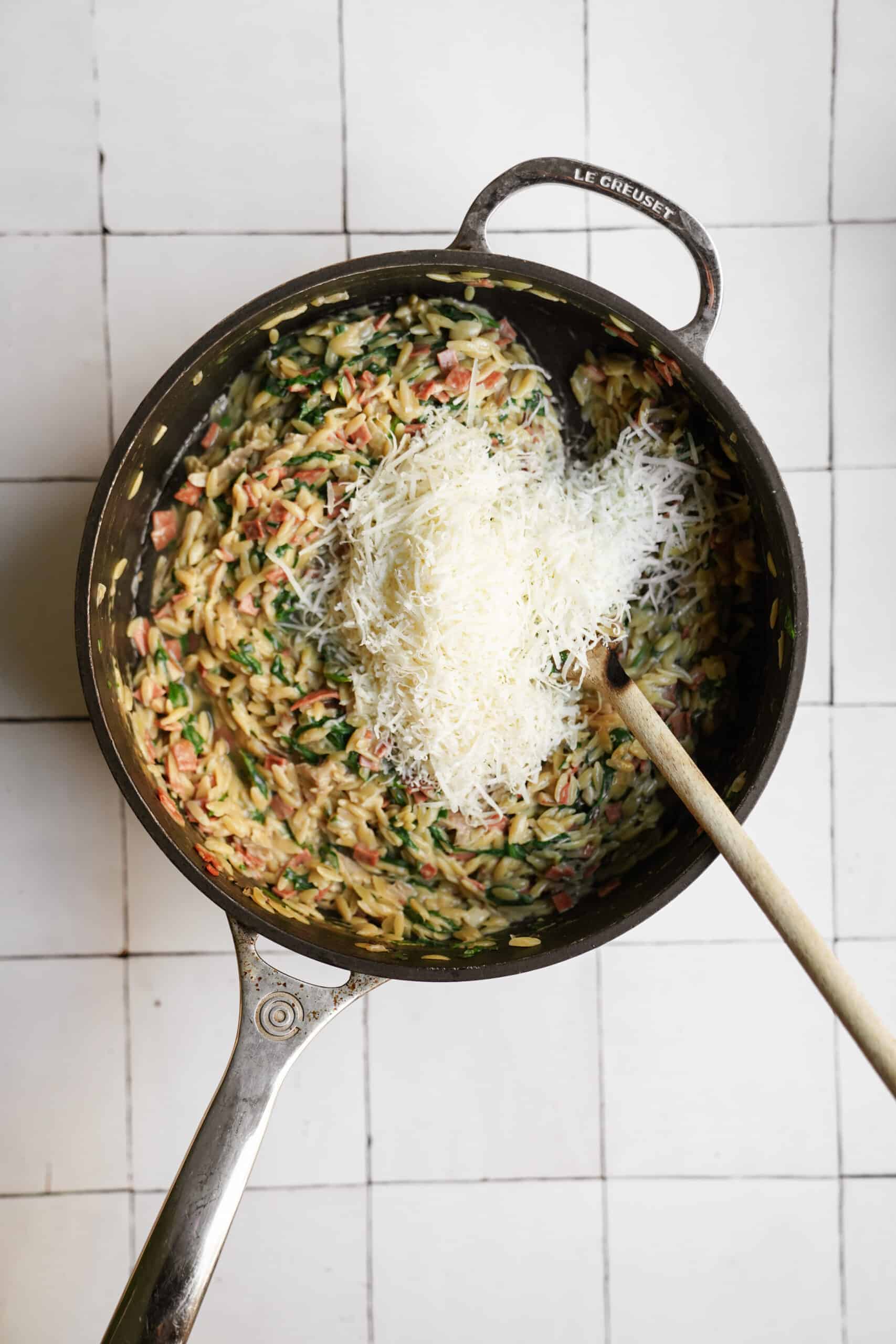 Parmesan added to orzo carbonara