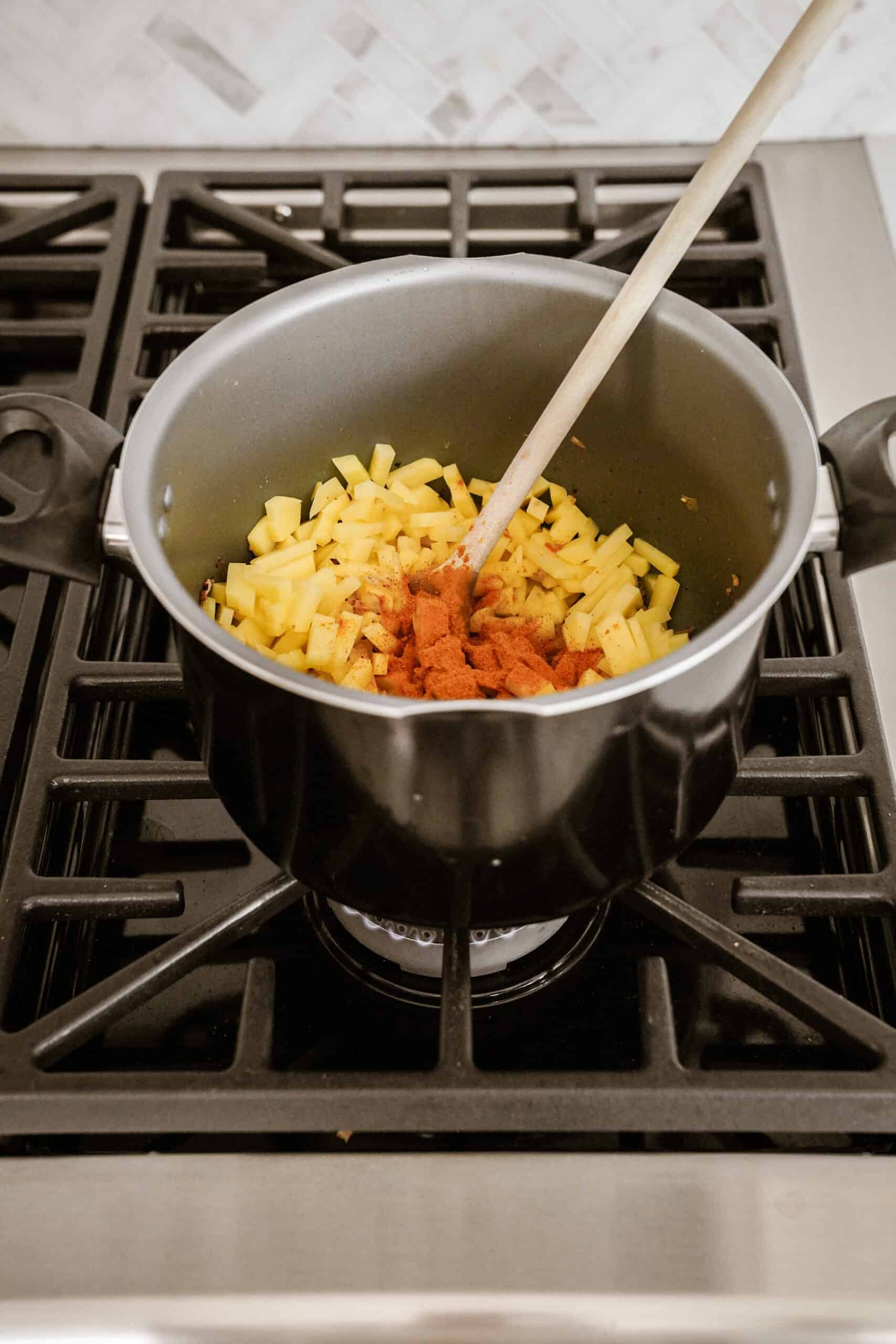 Spices and potatoes in a pot over the stove for soup
