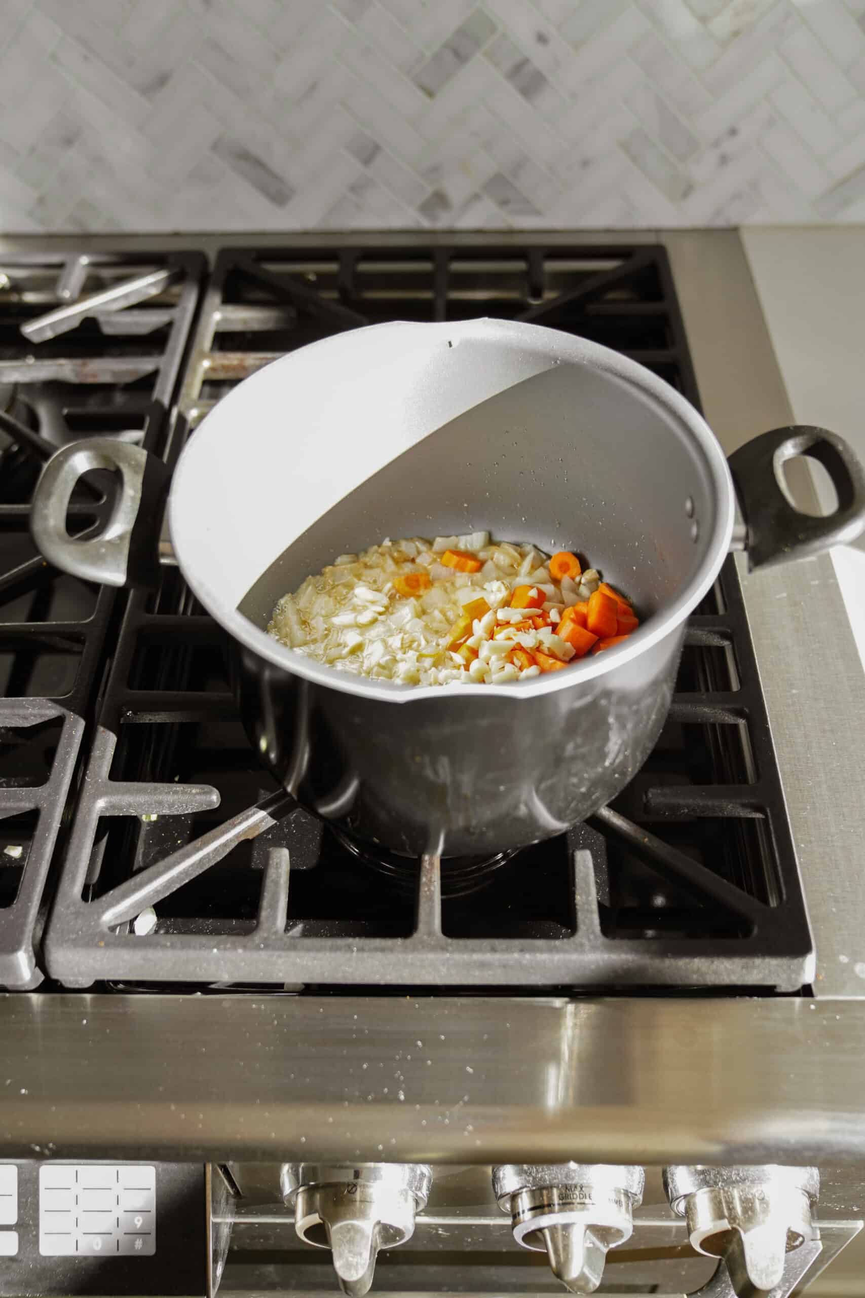 Onions, garlic and carrots cooking in a pot