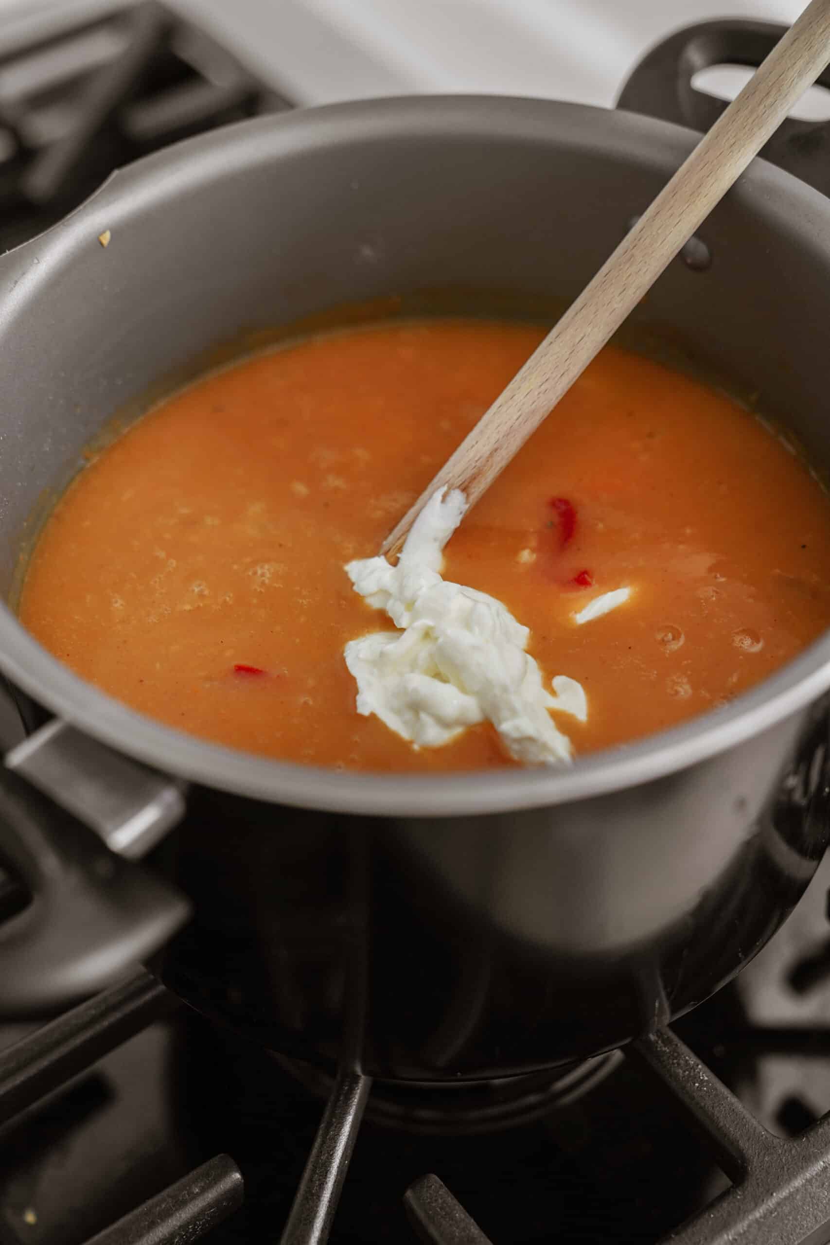 Cream being added into soup pot