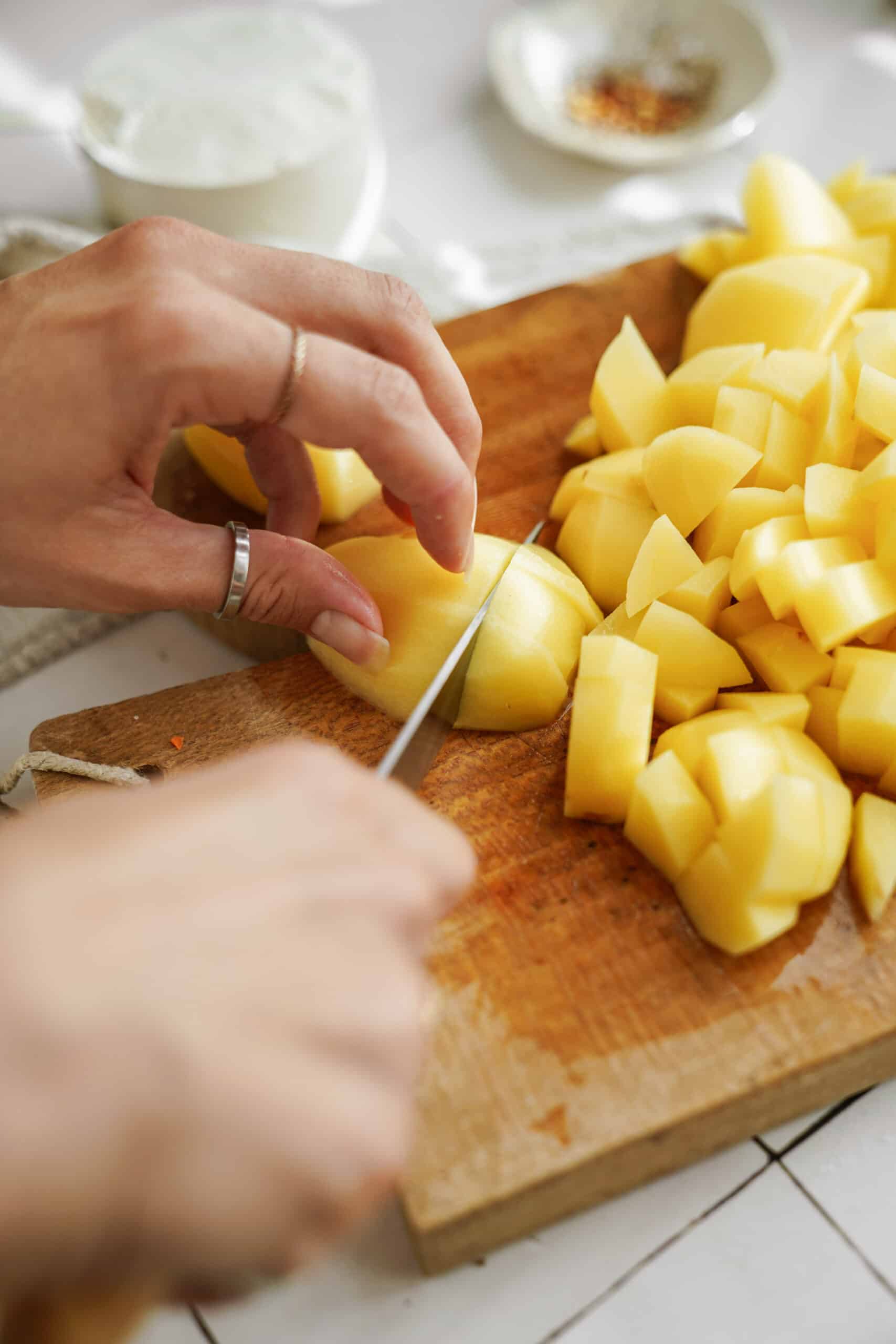 Potatoes being cut on cutting board