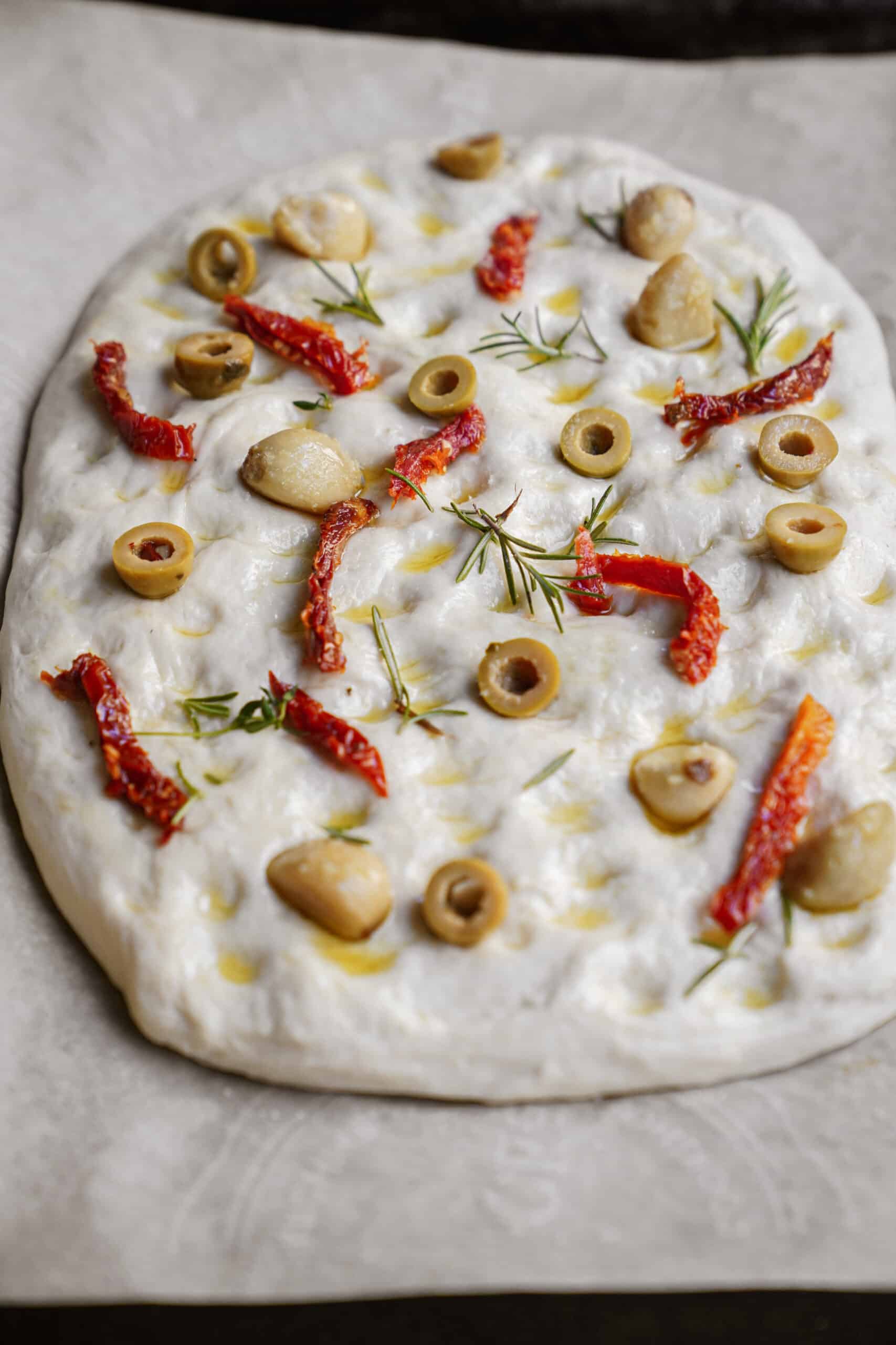 Ingredients laid on dough for Focaccia Bread Recipe