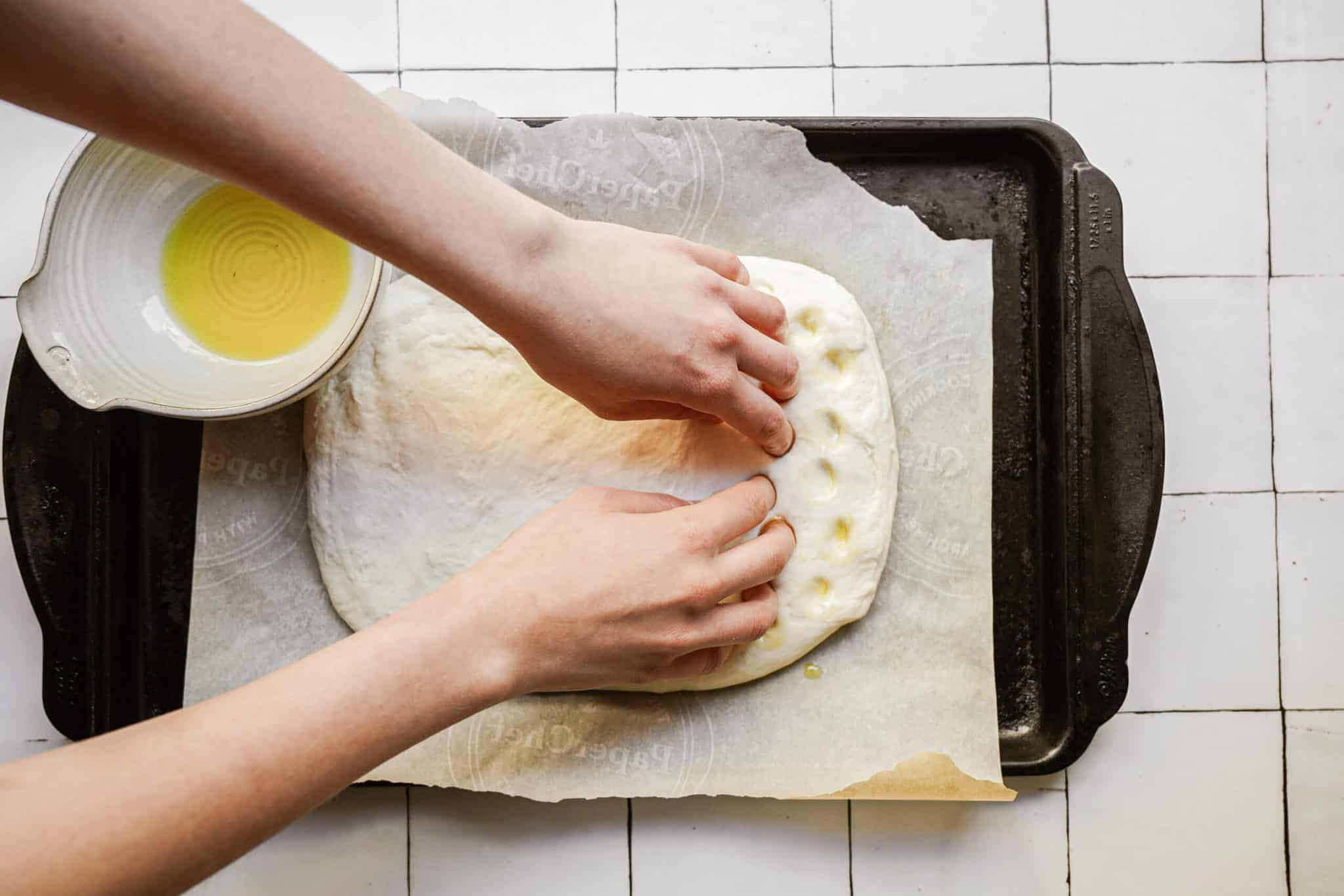 Dough being spread out for Focaccia Bread Recipe