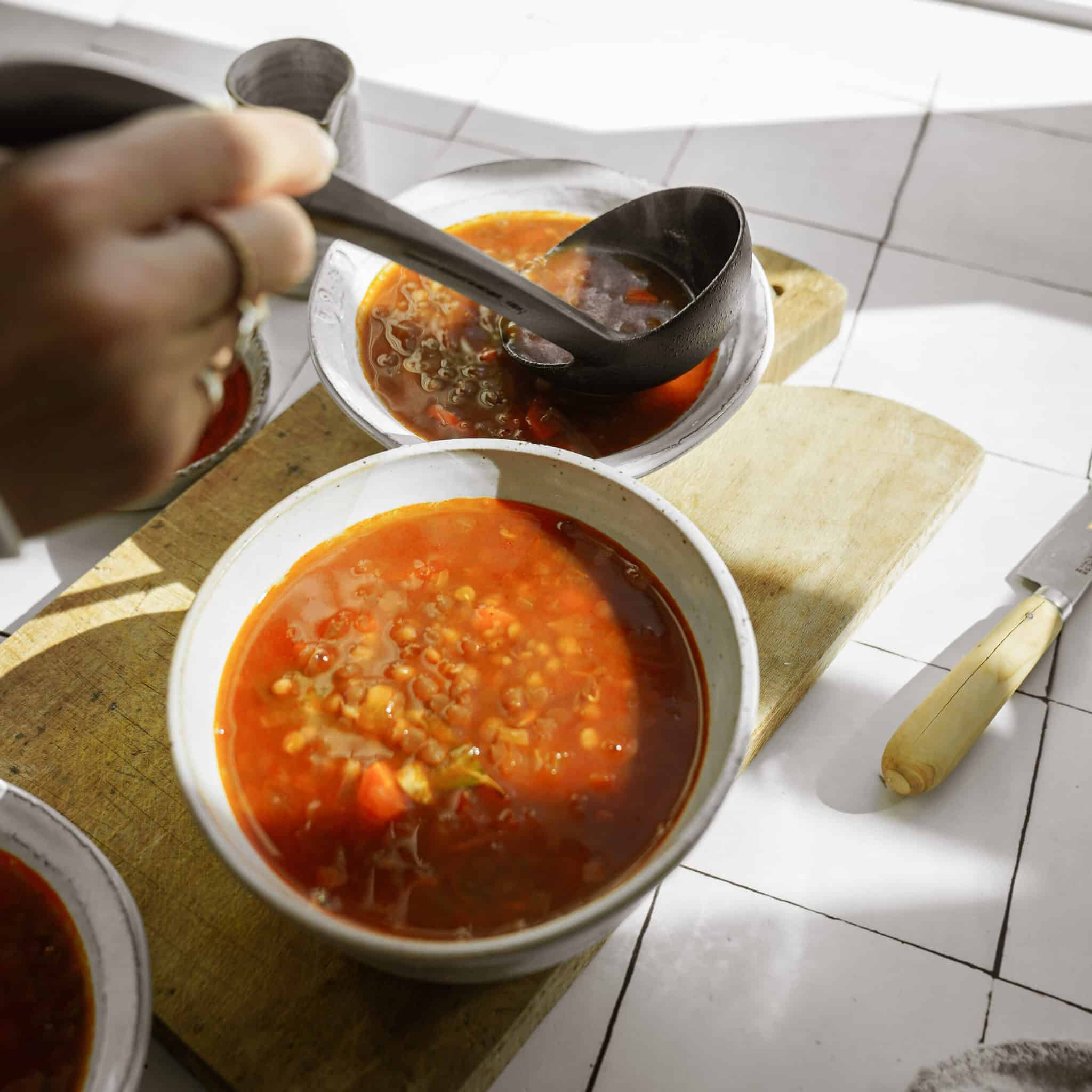 Greek lentil soup being scooped with a spoon