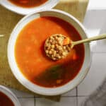Greek lentil soup being scooped with a spoon