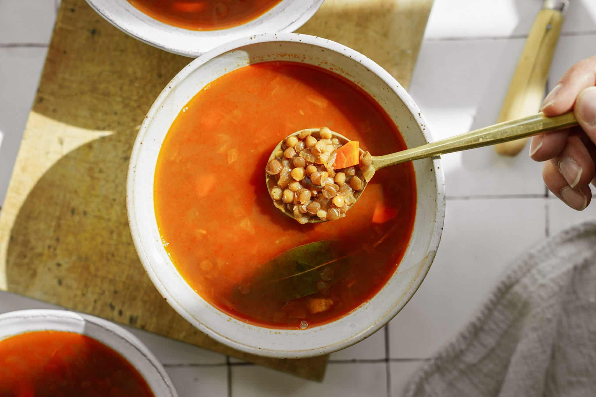 Greek lentil soup being scooped with a spoon