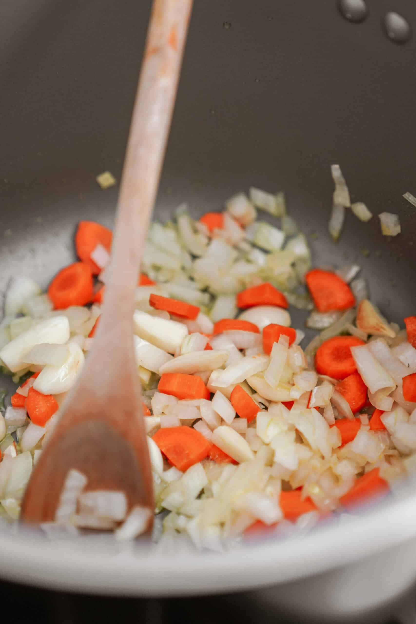 Onions and carrots in a soup pot