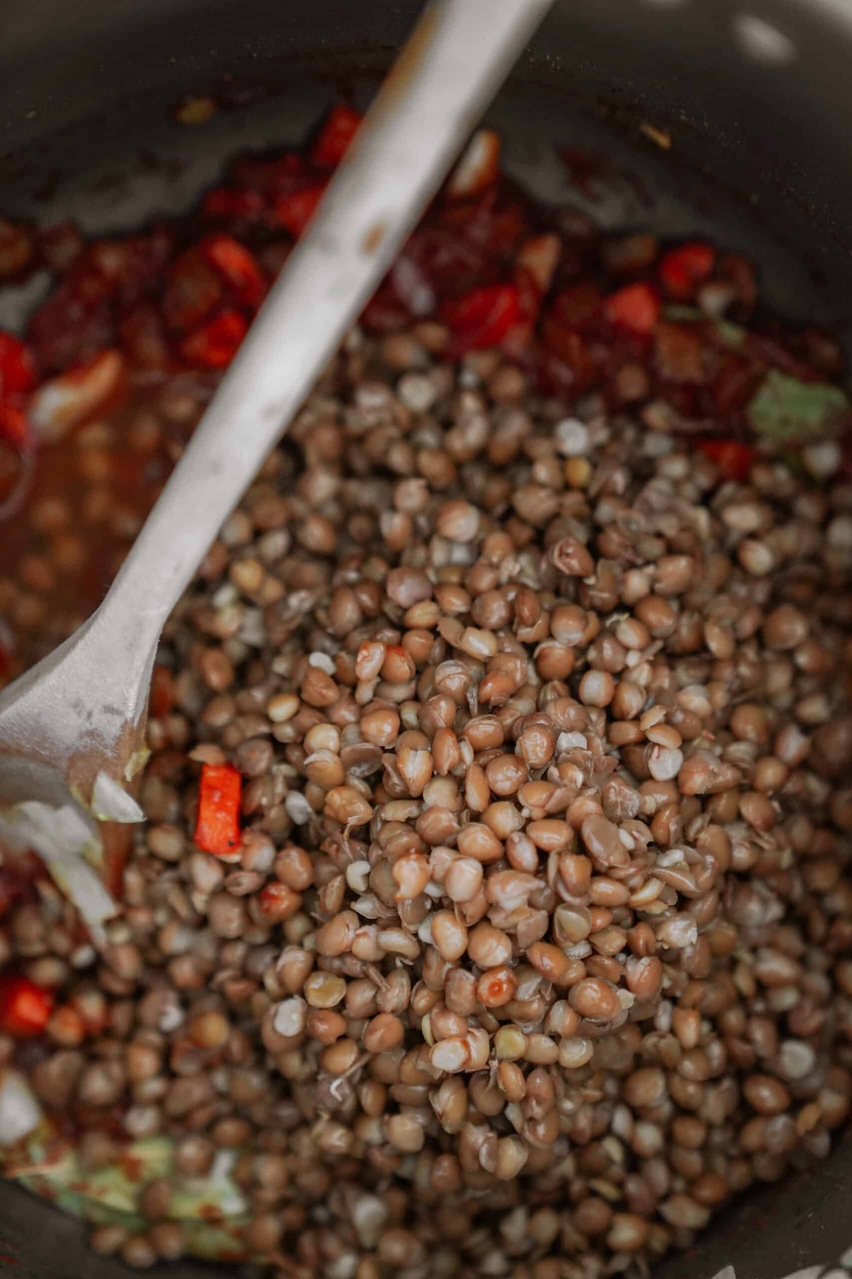 Lentils being added into a soup pot