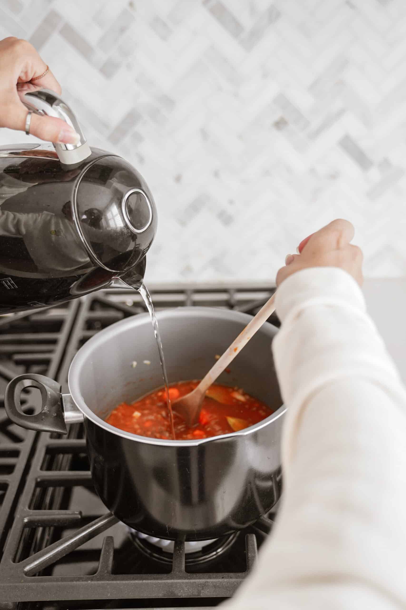 Water being poured into a soup pot