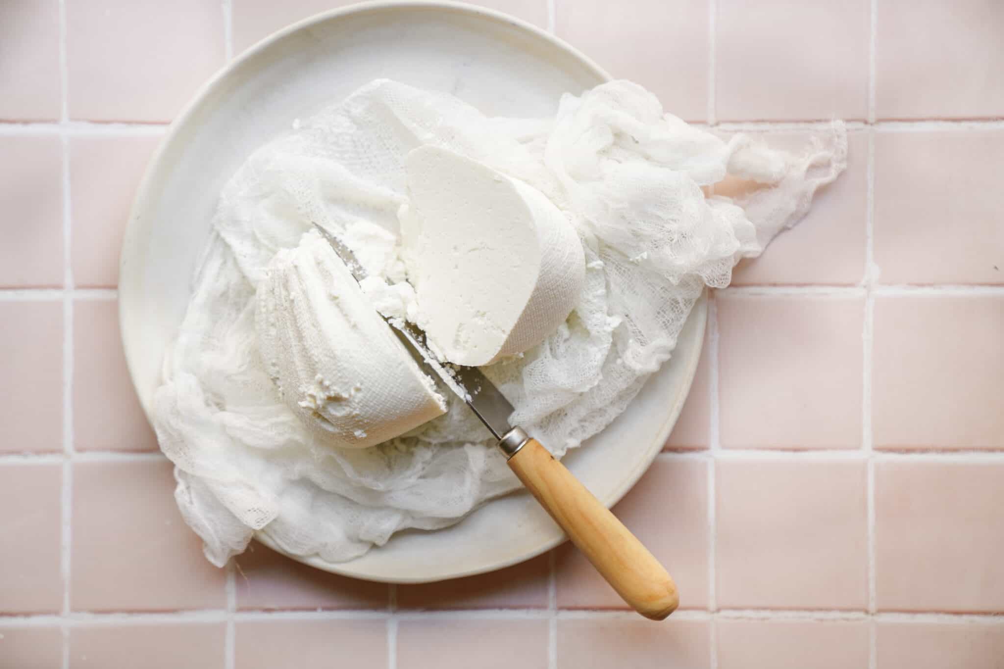Knife cutting into labneh