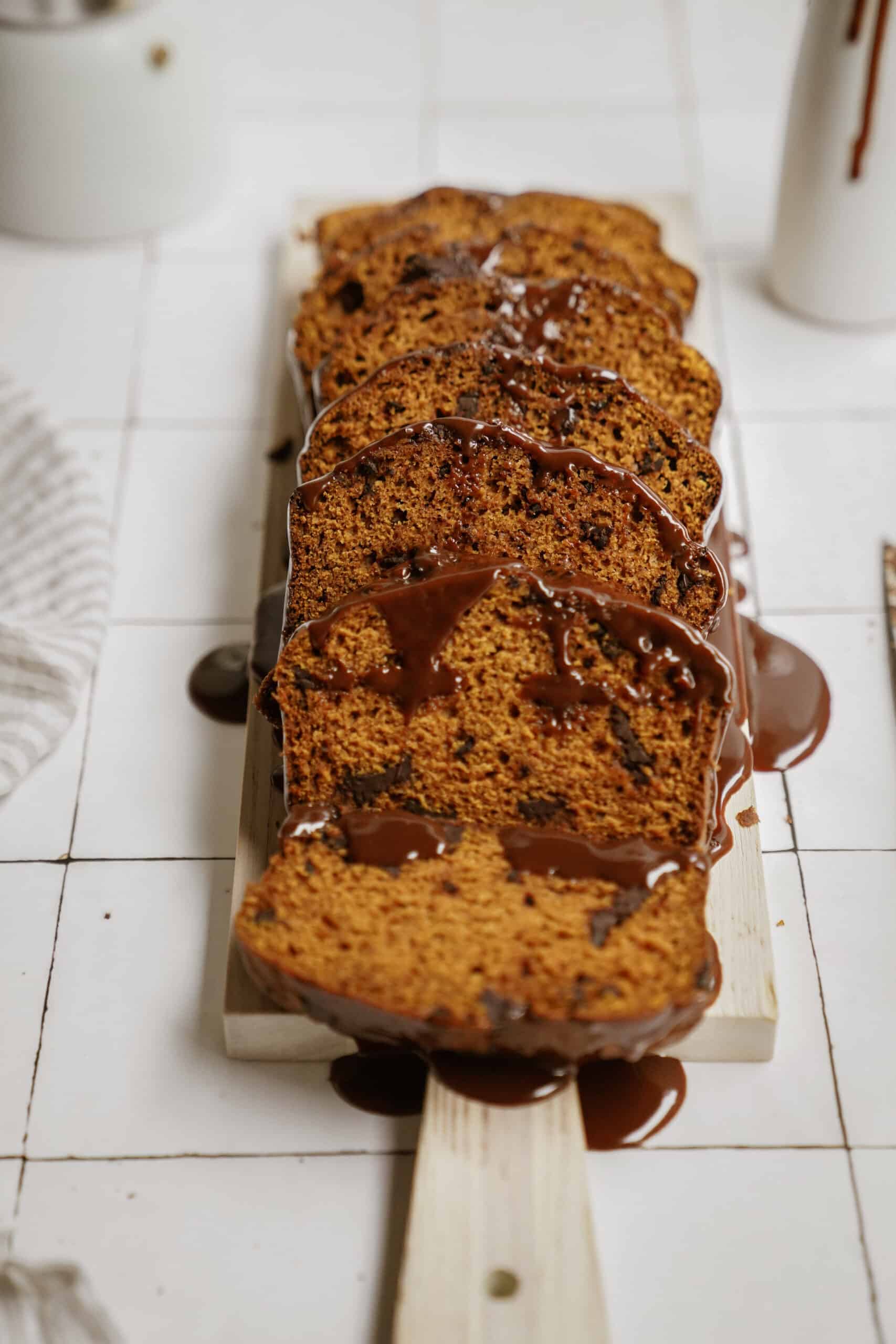 pumpkin chocolate chip bread sliced on a cutting board