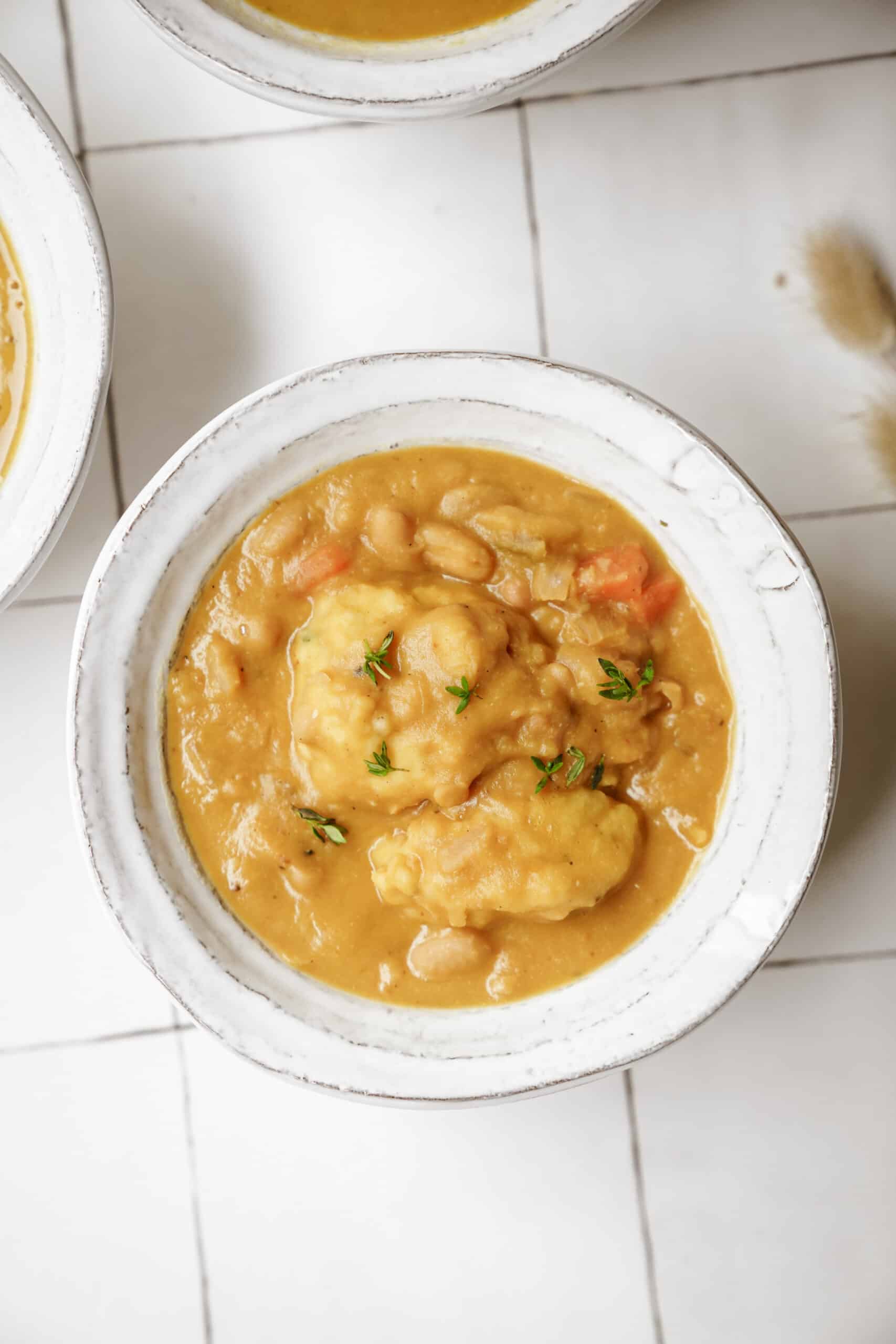 White bean soup with soup dumplings in bowls on countertop 