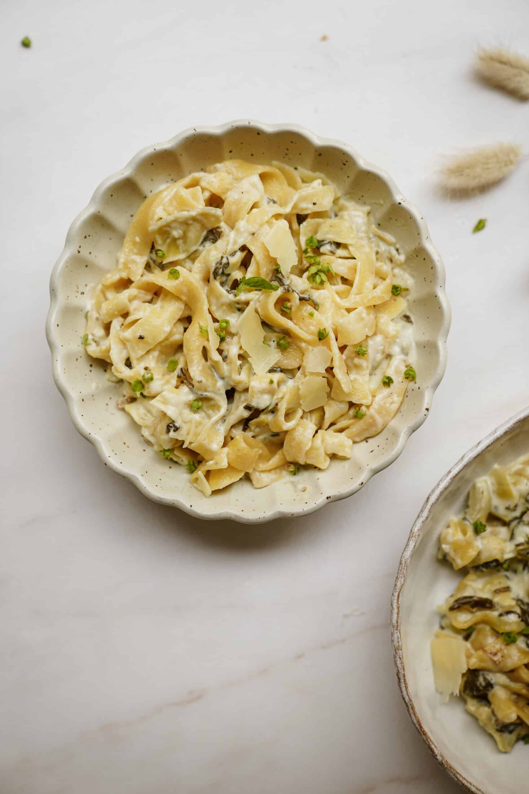 Spinach and artichoke pasta on white plates
