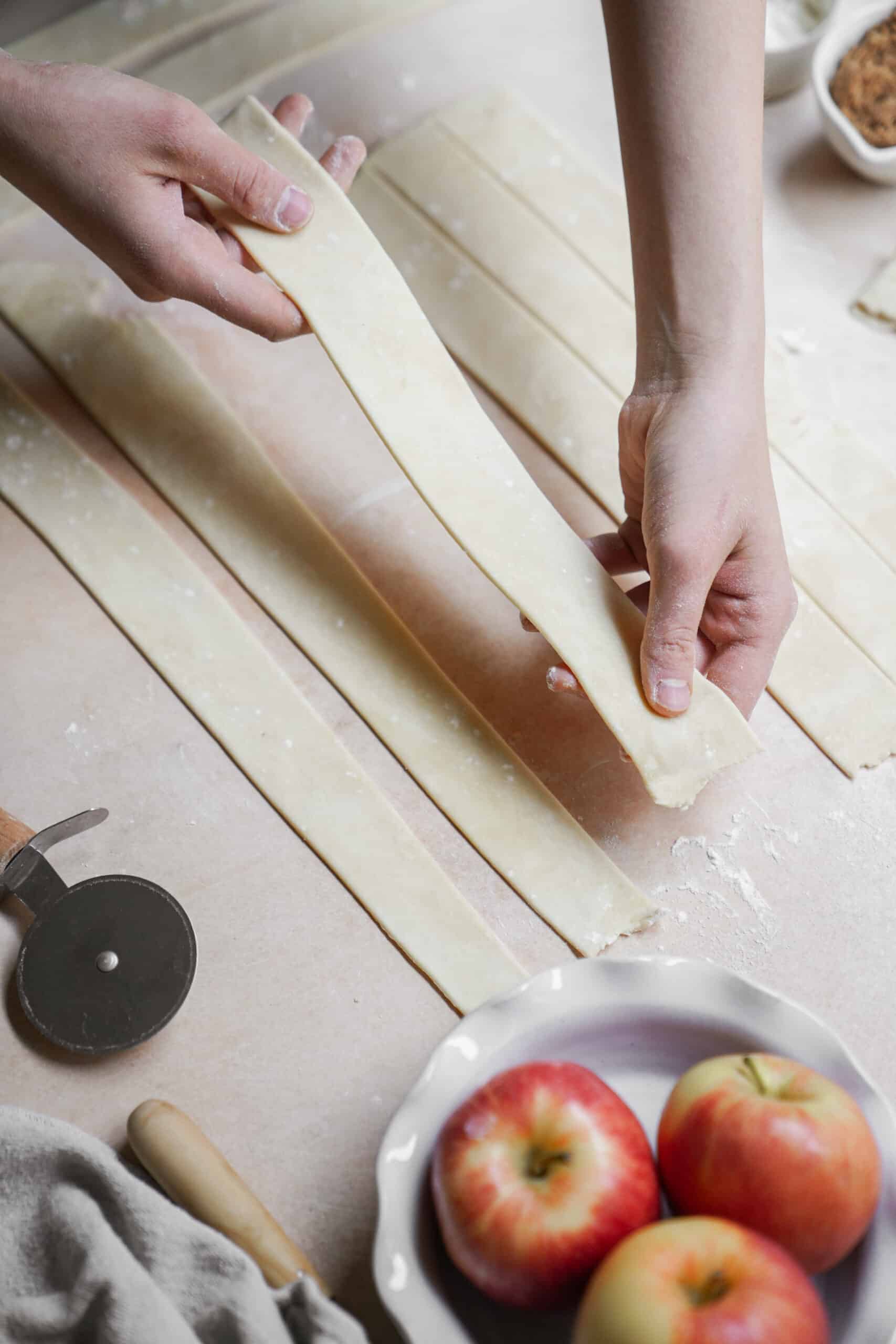 Dough strips being laid out for apple pie